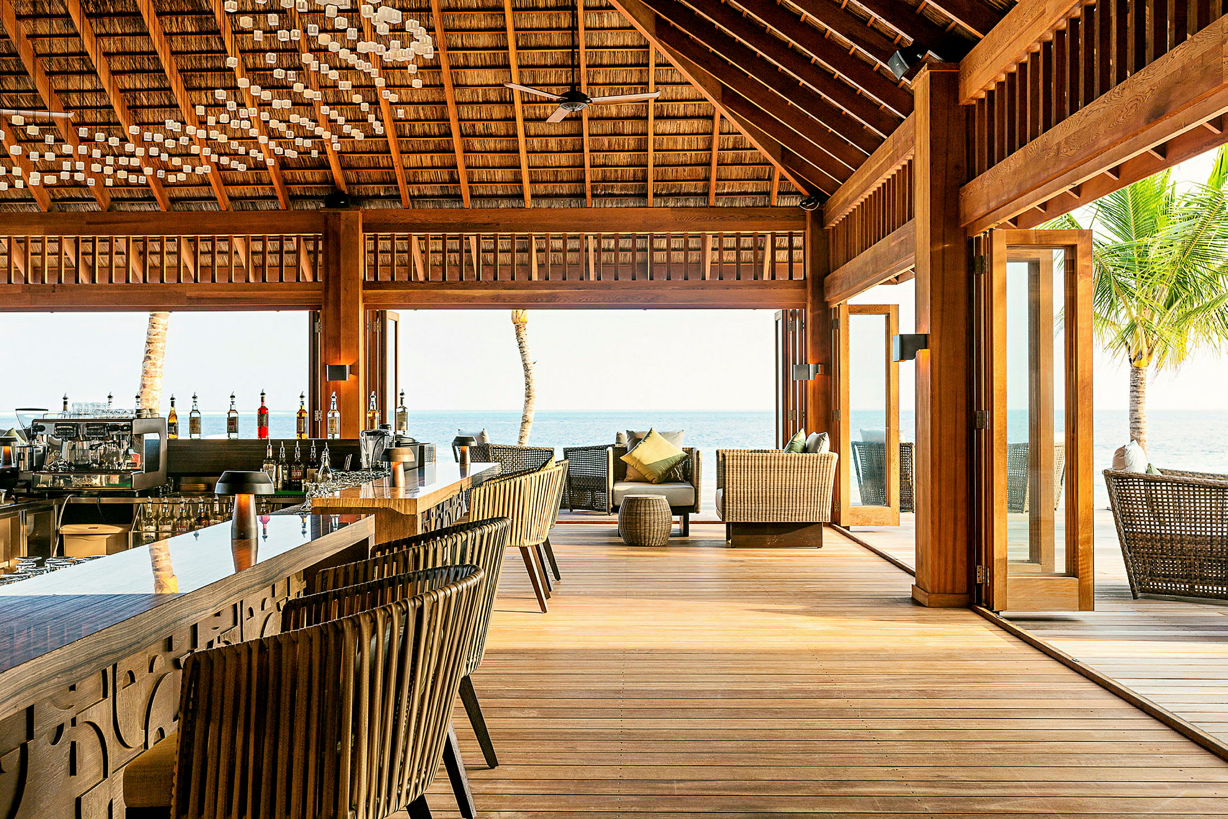En udendørsbar og lounge med træinteriør nær havet. (AI-genereret tekst)