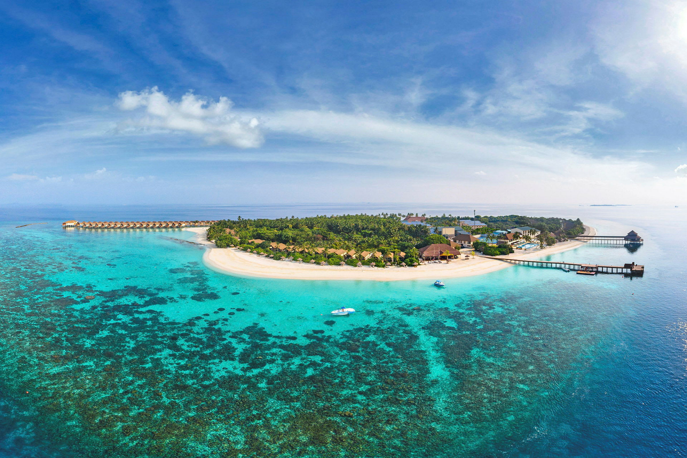 Luftfoto af en tropisk ø med hvide sandstrande omgivet af turkis vand og koralrev. (AI-genereret tekst)