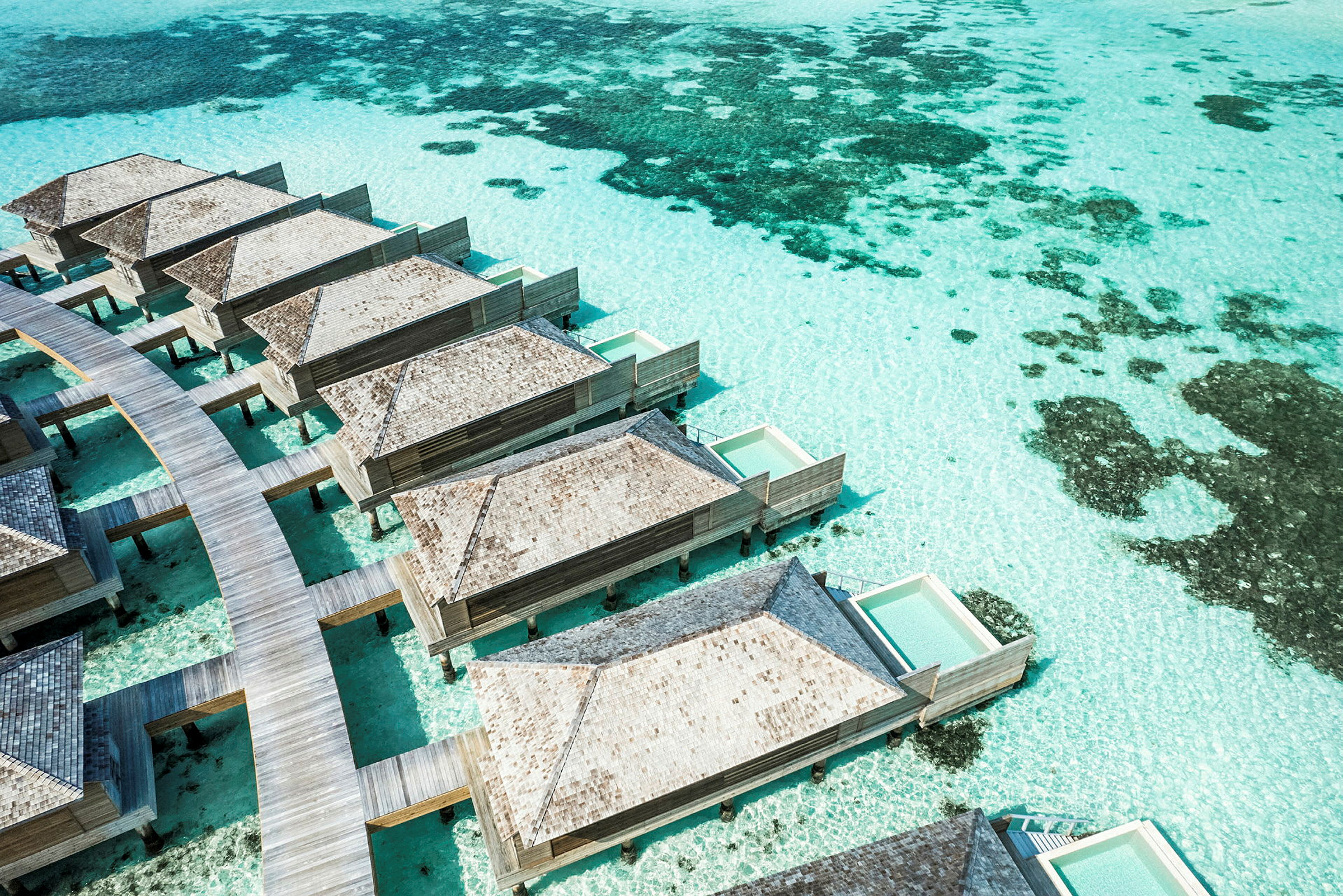 Bungalows på pæle med private pools over turkis vand. (AI-genereret tekst)