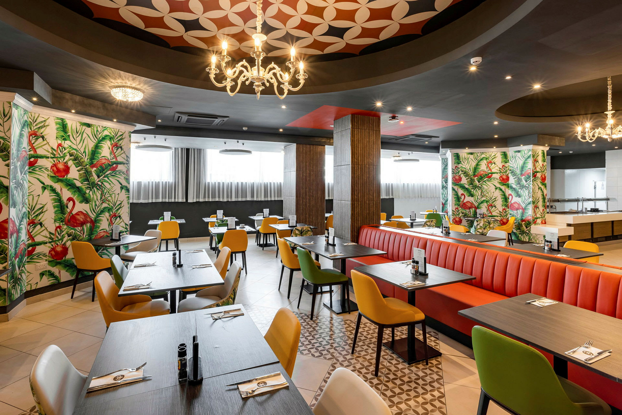 Restaurant med farverige stole og borde, dekoreret med flamingo-mønstret tapet. (AI-genereret tekst)