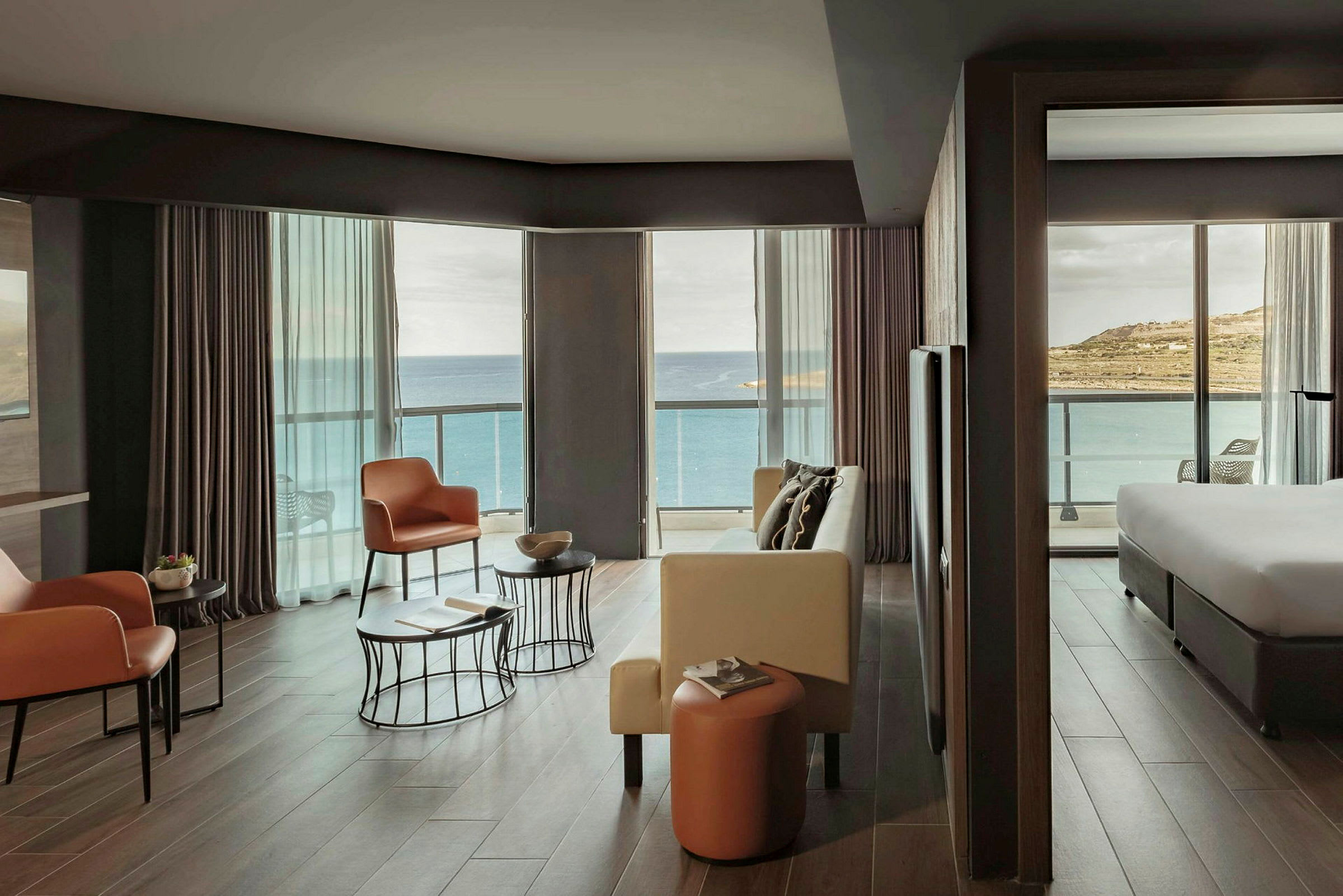 Et hotelværelse med moderne indretning og store vinduer med udsigt over havet. (AI-genereret tekst)