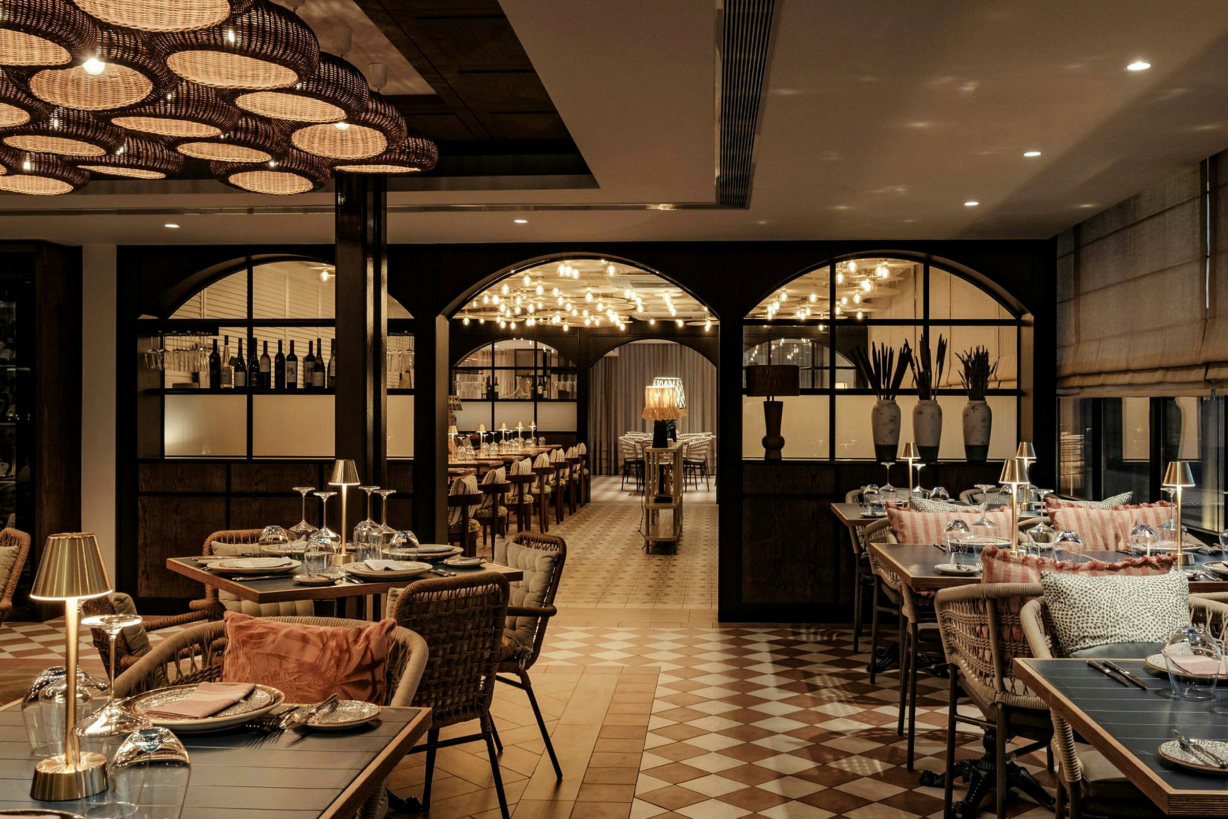 En elegant restaurant med dækkede borde, dekorative lamper og en atmosfære af luksuriøs indretning. (AI-genereret tekst)