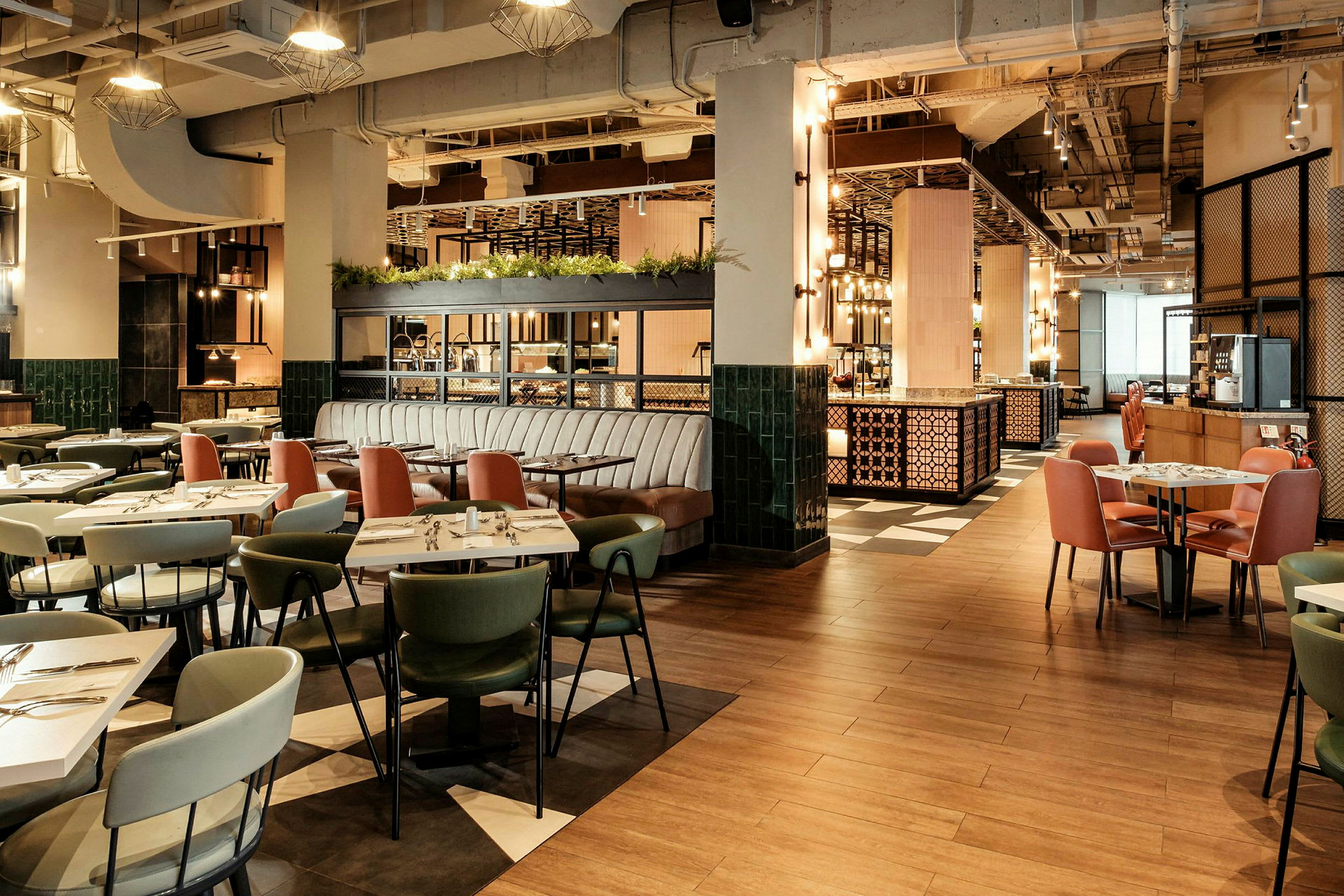 Billede af en moderne restaurant med borde og stole i forskellige farver, lys belysning og en luftig indretning. (AI-genereret tekst)