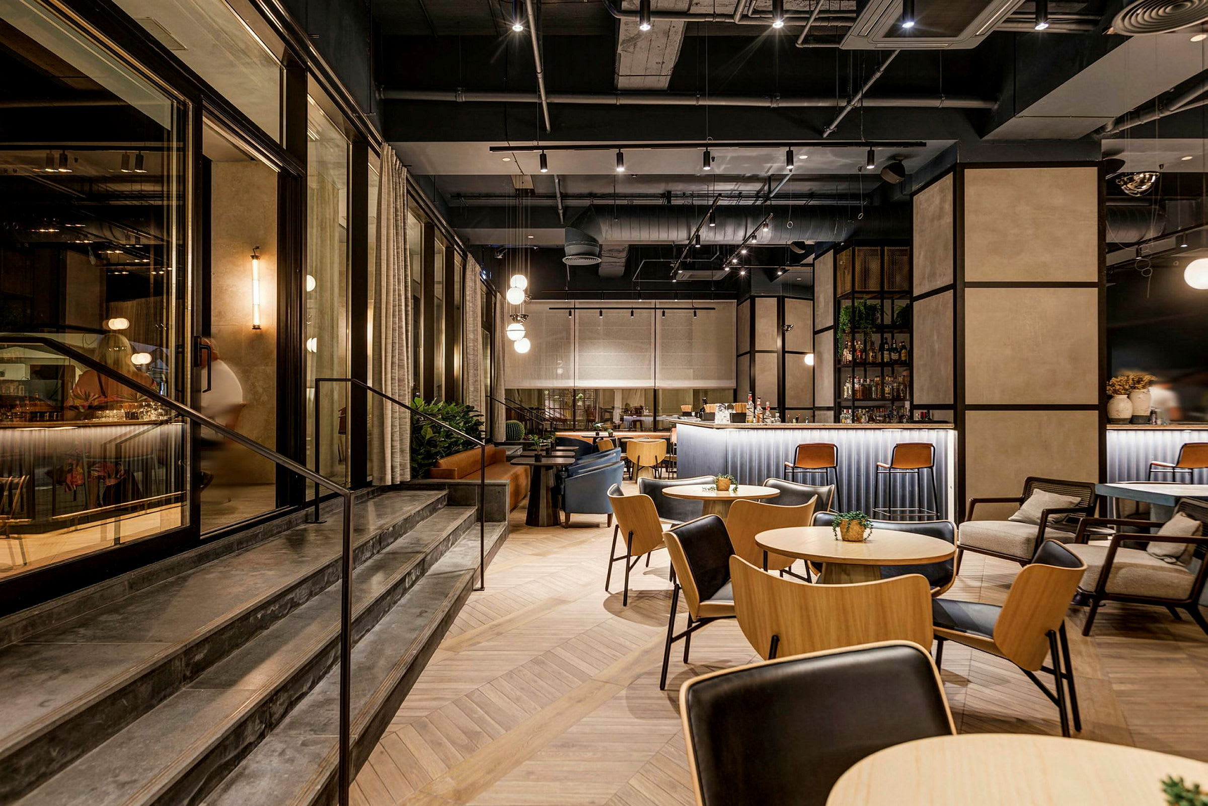 Interiør af en moderne restaurant med borde, stole og en bardisk. (AI-genereret tekst)