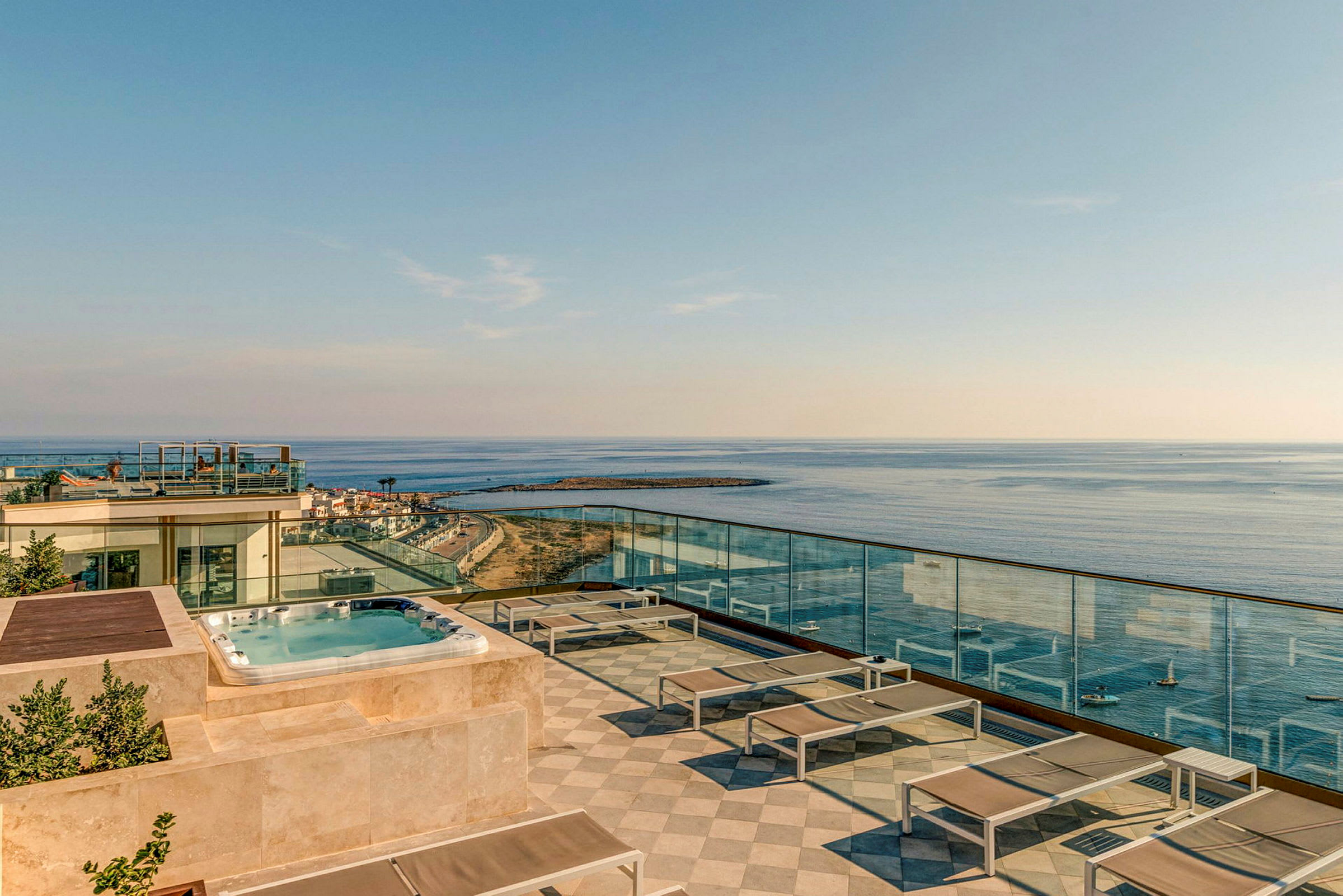 Tagterrasse med pool, liggestole og udsigt over havet. (AI-genereret tekst)