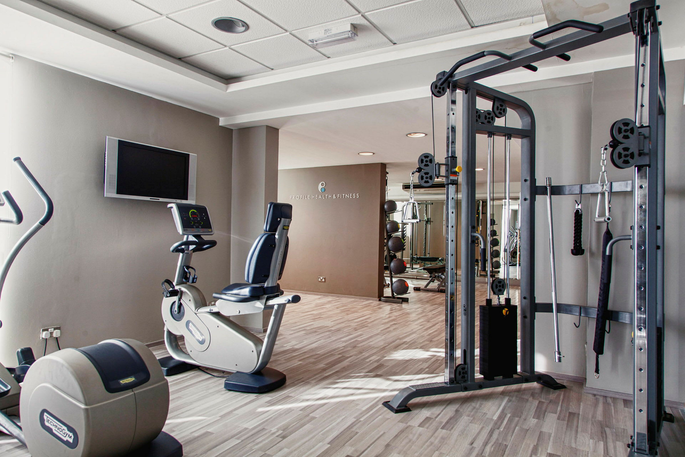 Et fitnesscenter med flere træningsmaskiner og udstyr. (AI-genereret tekst)