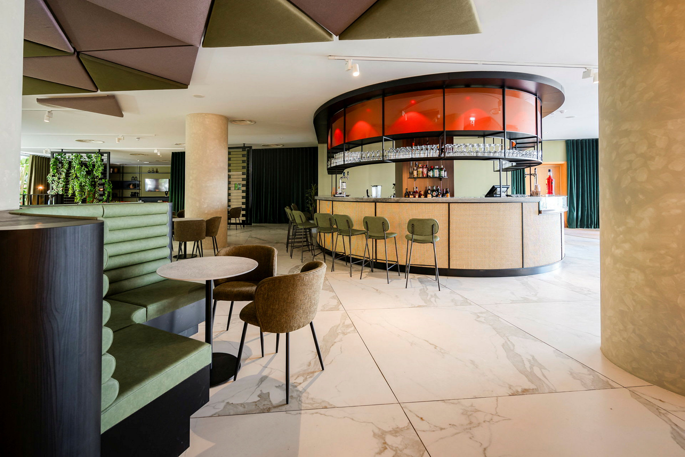 Interiør af en moderne bar med en rund bardisk og stole, omkringliggende siddepladser og dekorative detaljer. (AI-genereret tekst)