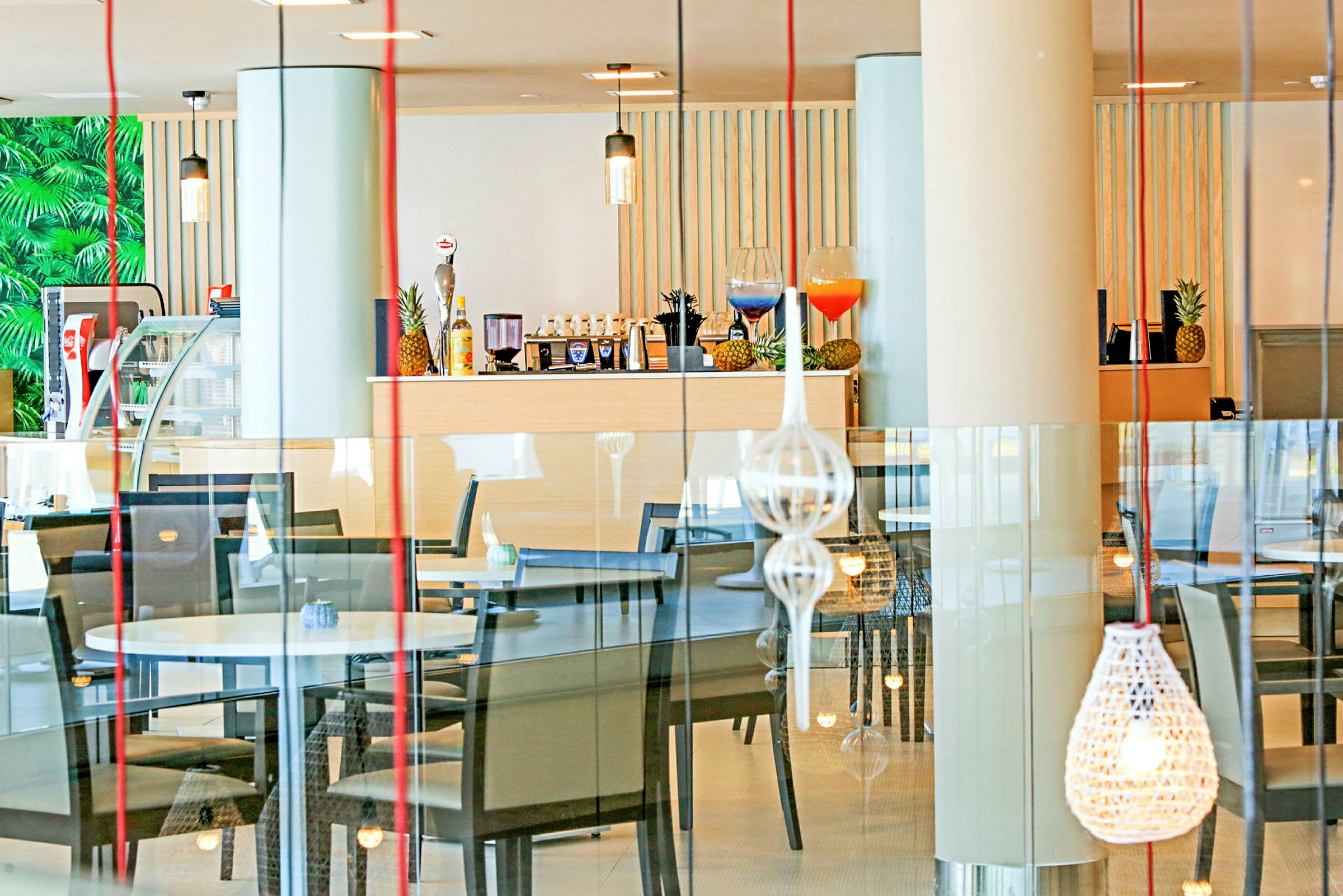 Inde i en restaurant med borde, stole og dekorative lamper. (AI-genereret tekst)