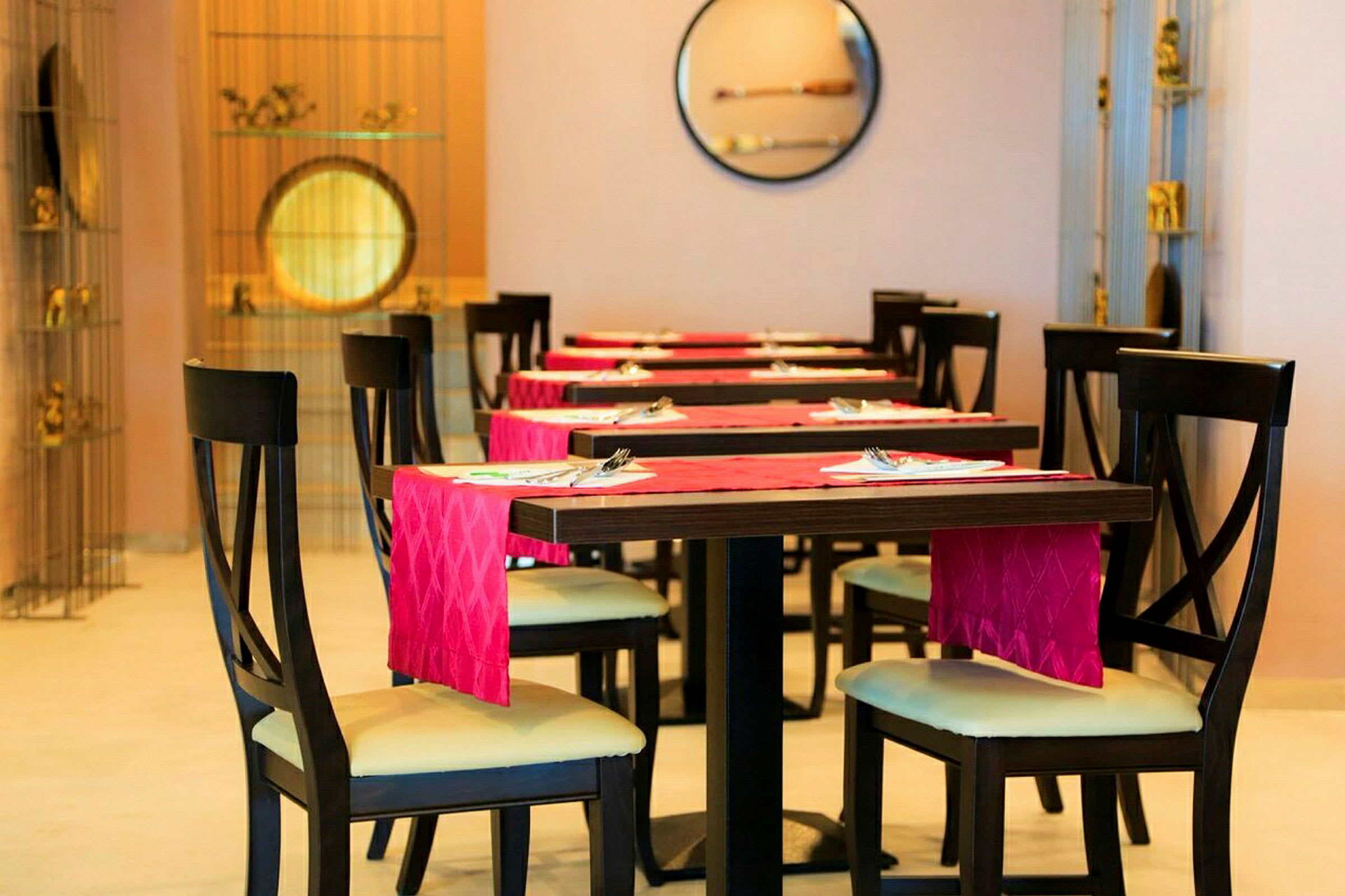 Restaurantbord og stole med rødt serviet. (AI-genereret tekst)