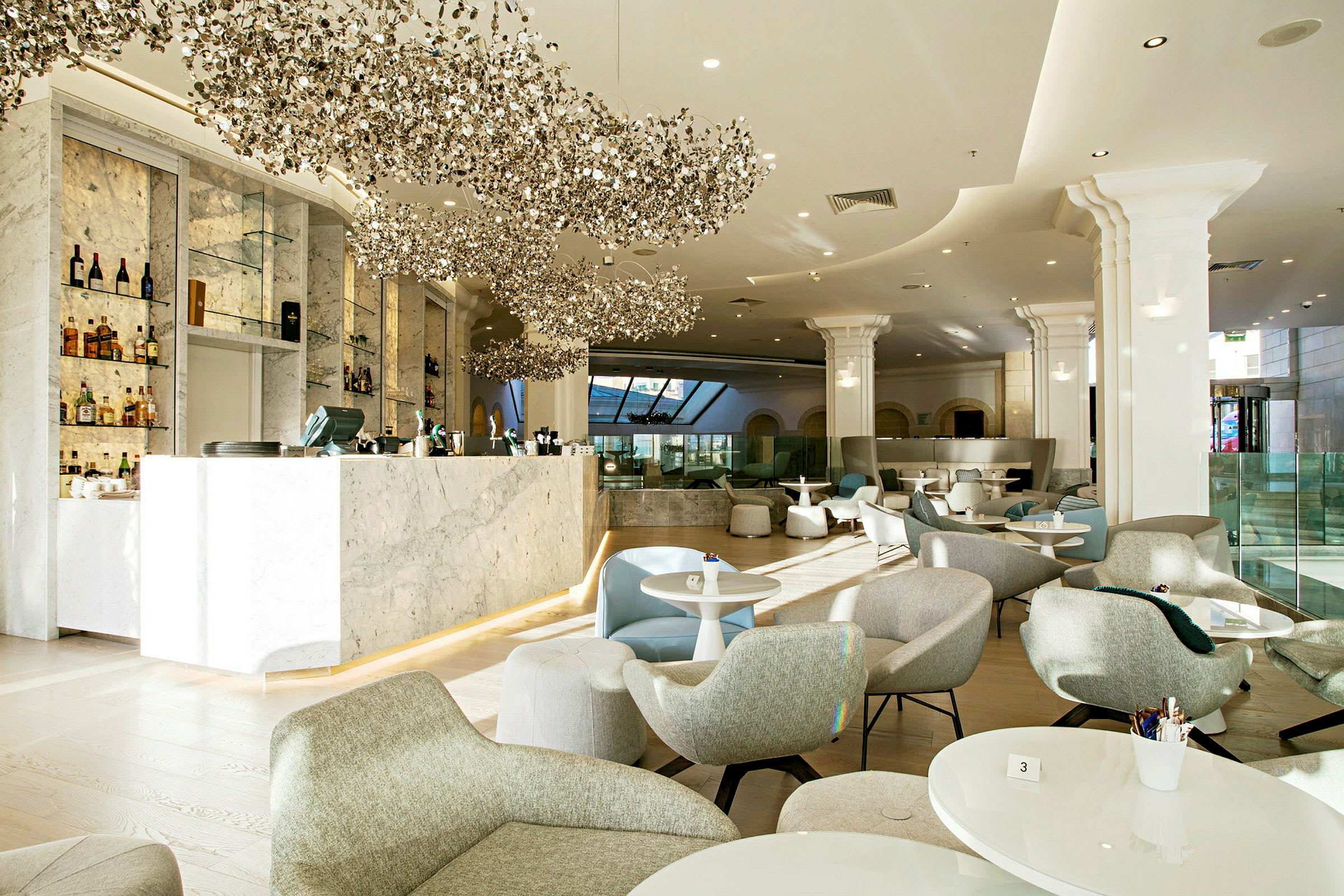Interiør af en lys og elegant bar med marmorbar og moderne siddepladser. (AI-genereret tekst)