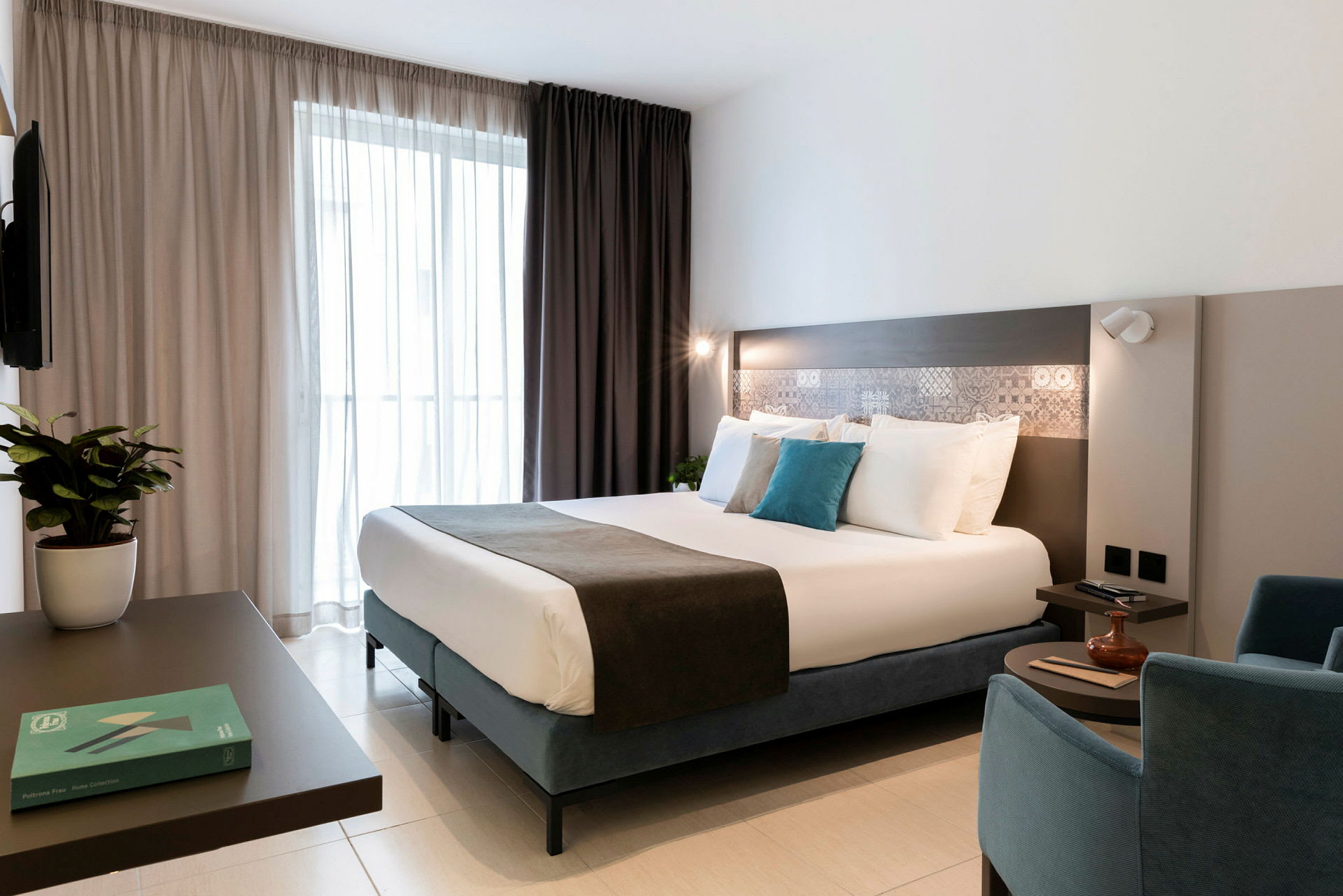 Et moderne hotelværelse med en dobbeltseng, siddepladser og indretningsdetaljer. (AI-genereret tekst)