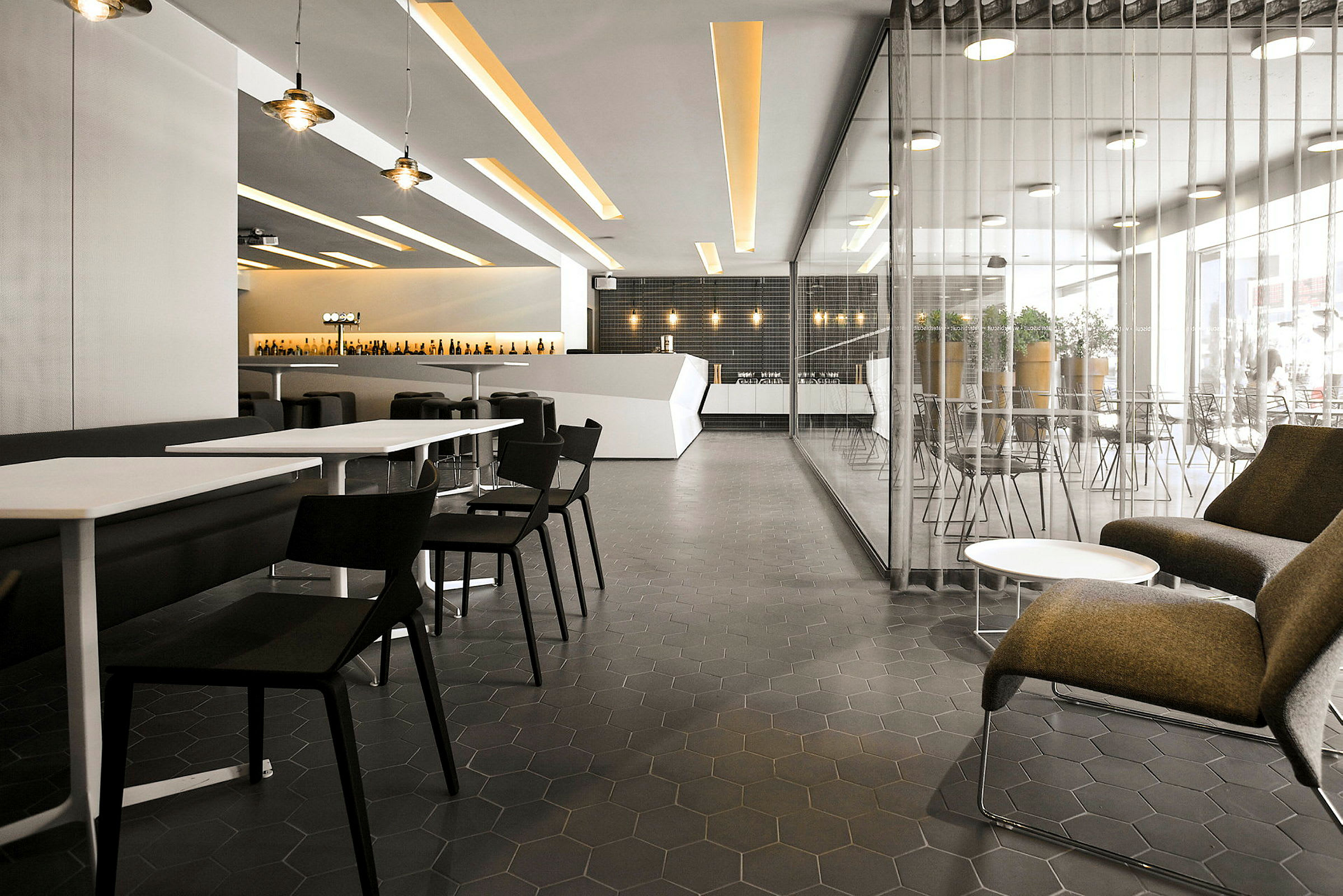 Interiør af en moderne restaurant med borde, stole og loungeområde. (AI-genereret tekst)
