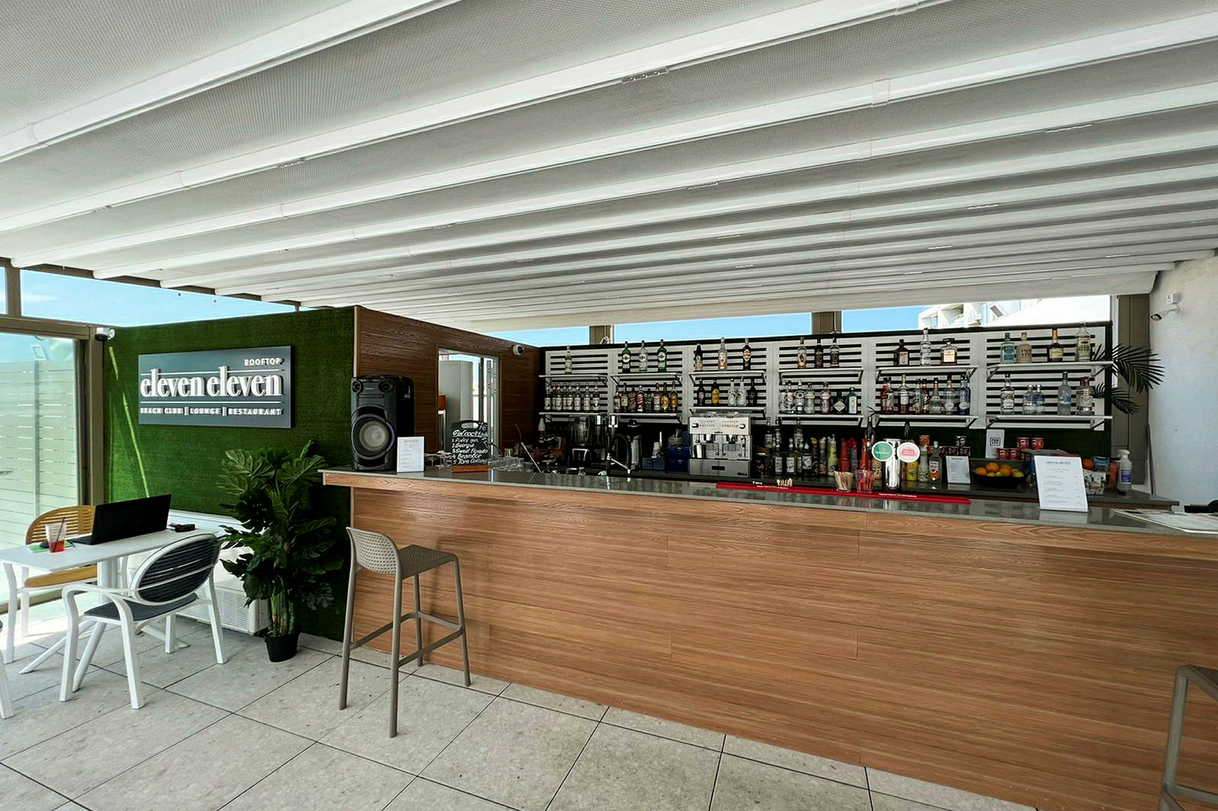 Moderne bar med træpaneler og en flaskereol i baggrunden. (AI-genereret tekst)