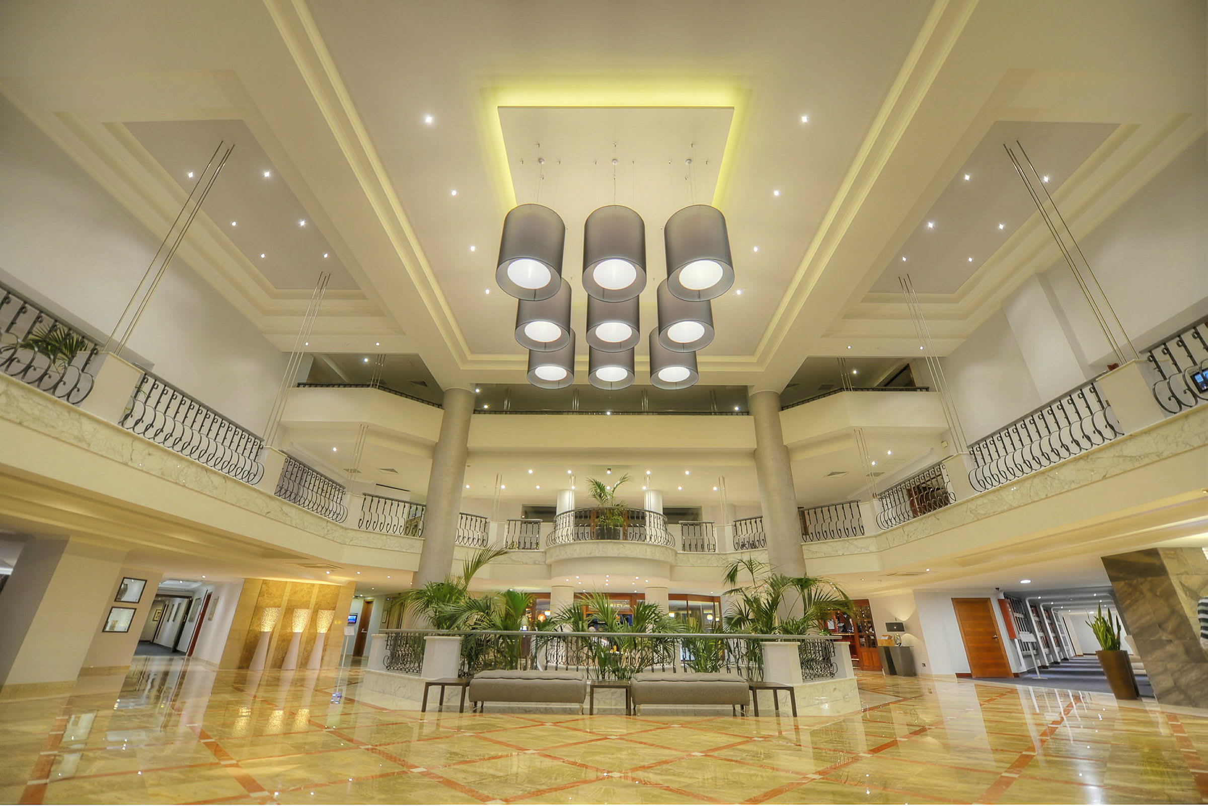 Billede af en elegant hotellobby med en lysekrone i midten og moderne indretning. (AI-genereret tekst)