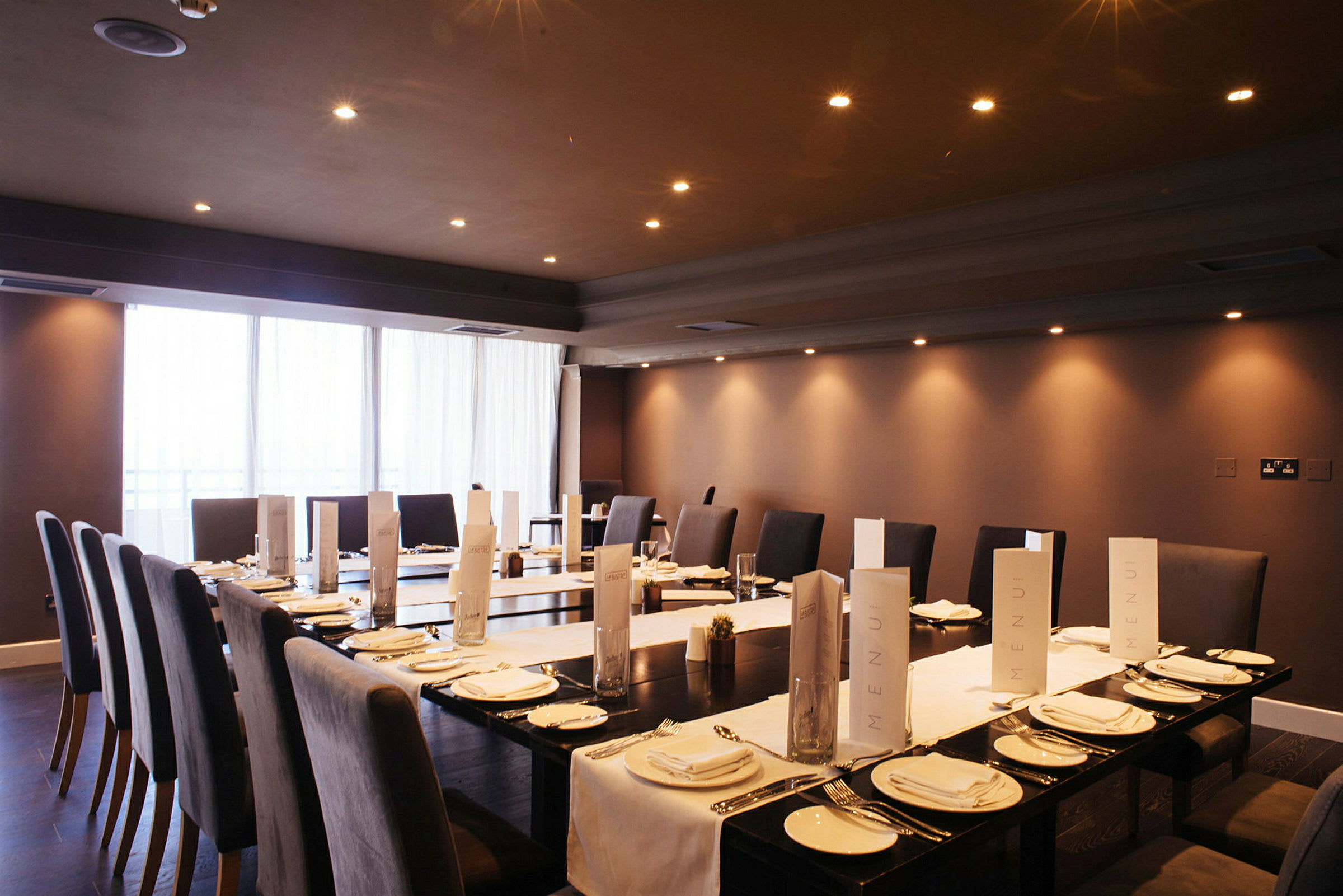 Et dækket bord i et elegant restaurantmiljø med menuer og passende belysning. (AI-genereret tekst)