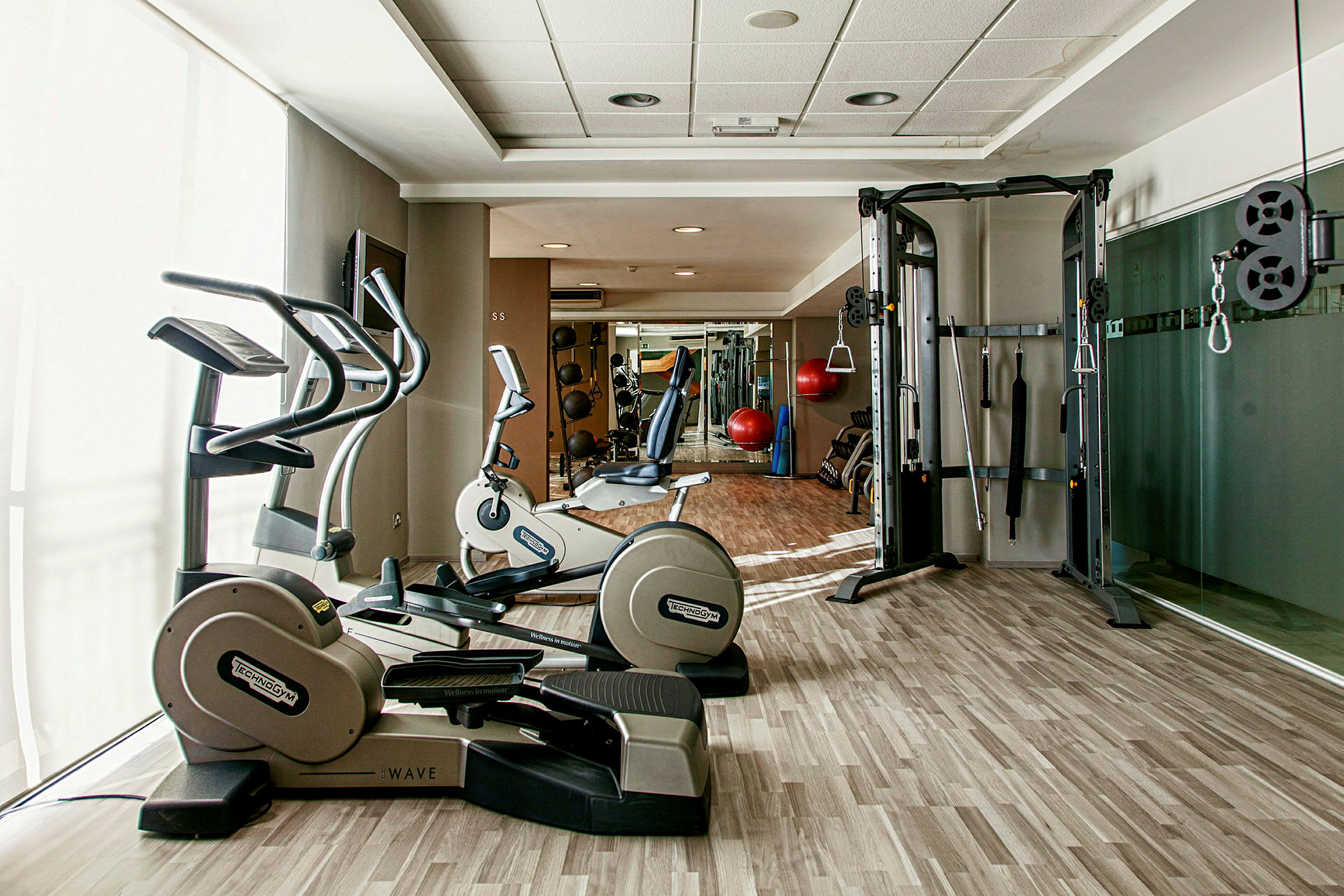 Et fitnesscenter med træningsmaskiner og udstyr, herunder motionscykler og kabelmaskiner. (AI-genereret tekst)
