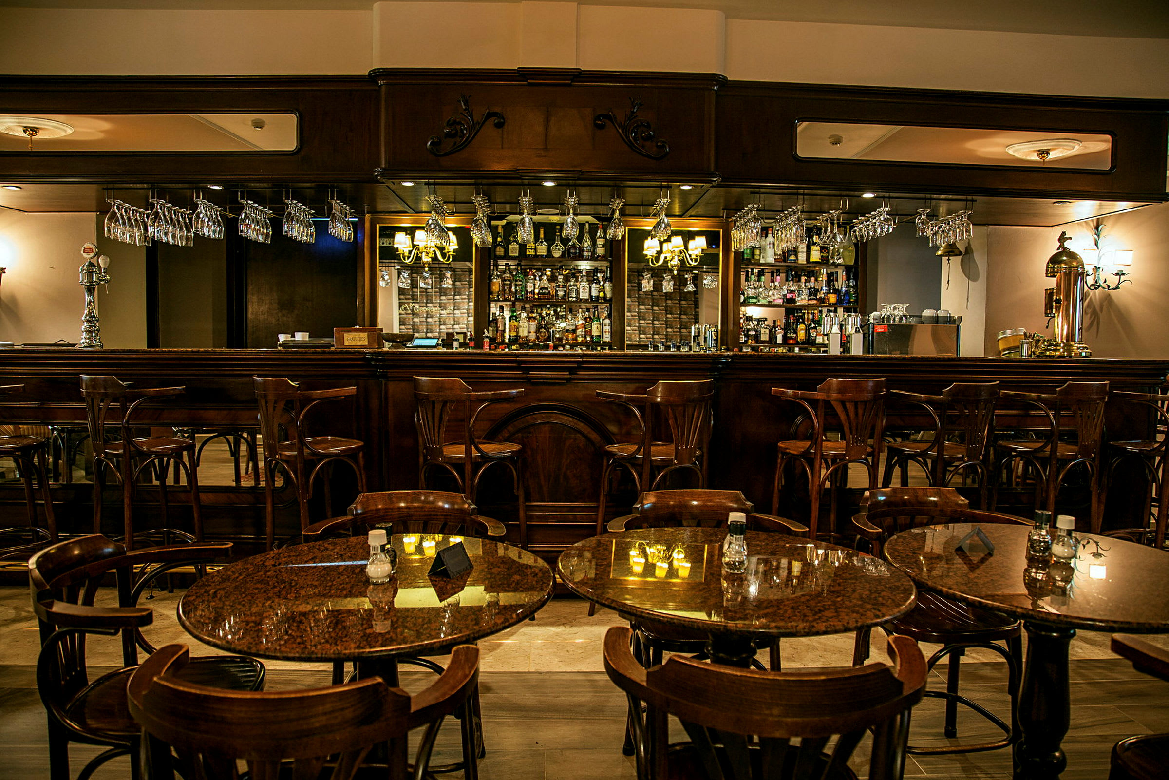 En elegant bar med træmøbler og bordopsætninger med stole i forgrunden. (AI-genereret tekst)