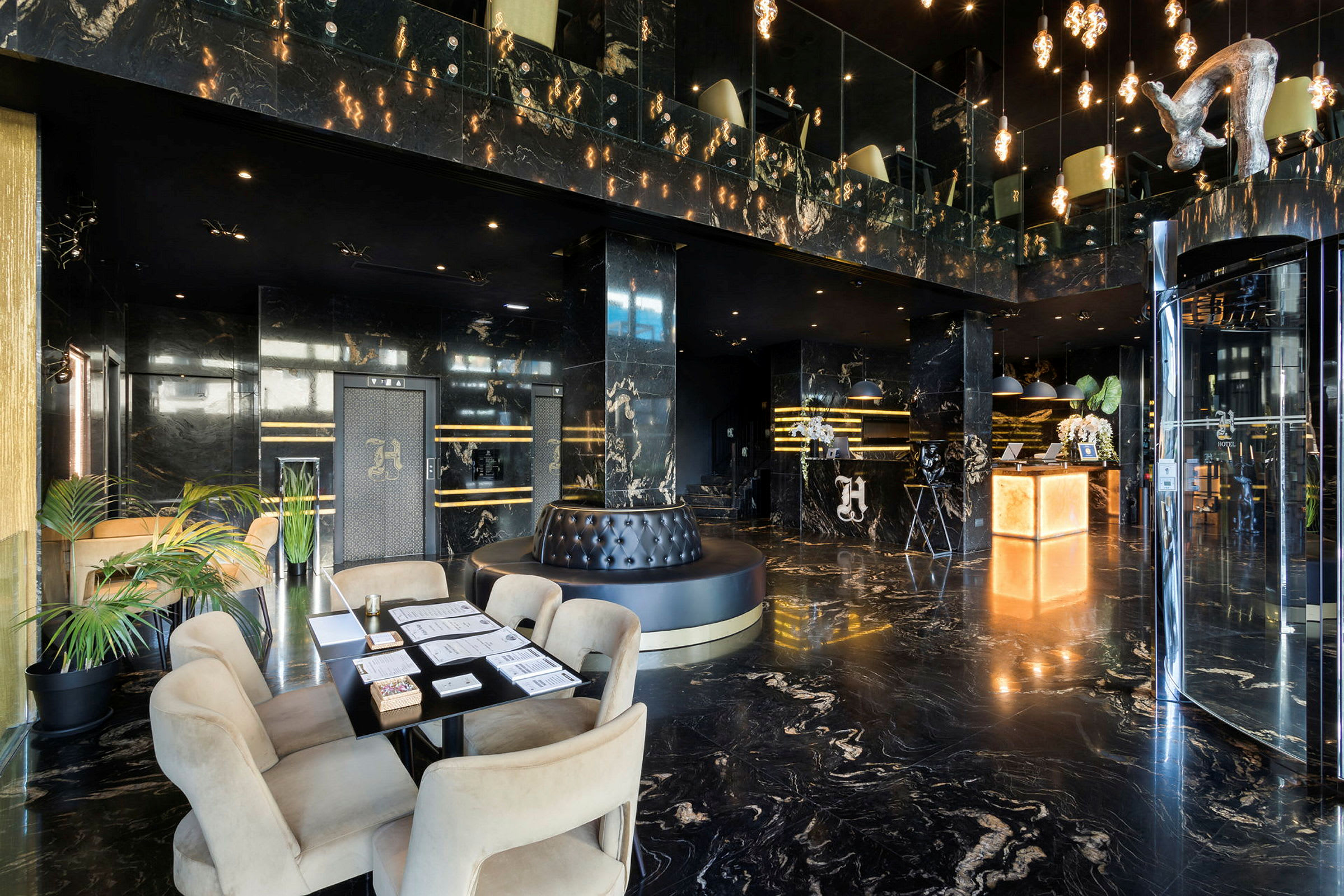 Billede af en hotellobby med elegant sort marmordesign, siddeområde og reception. (AI-genereret tekst)
