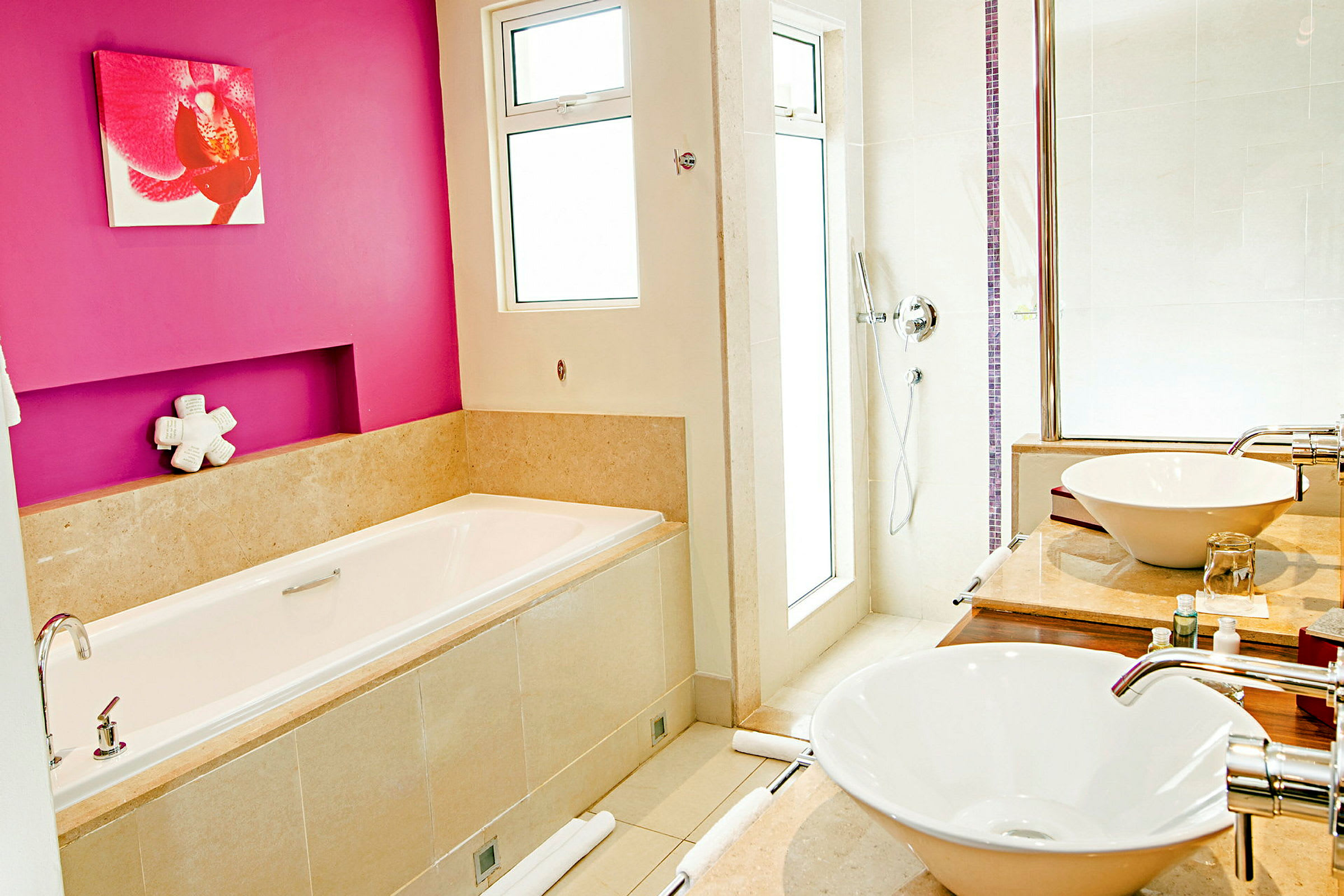 Et moderne badeværelse med pink vægge, badekar og to håndvaske. (AI-genereret tekst)