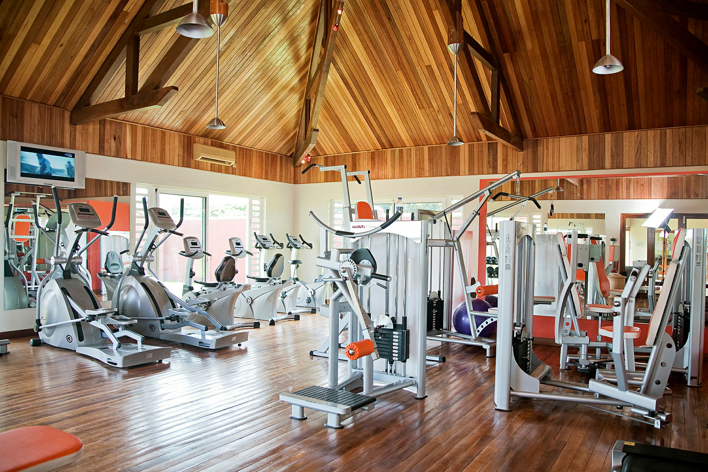 Et fitnesscenter med træningsmaskiner og trævægge. (AI-genereret tekst)