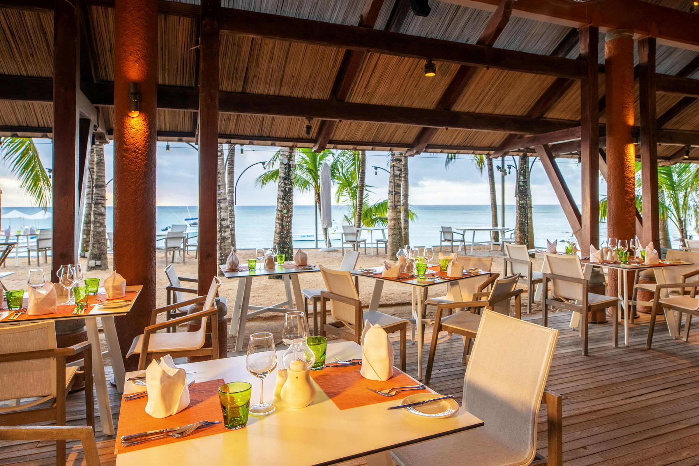 Restaurant med dækkede borde ved stranden. (AI-genereret tekst)