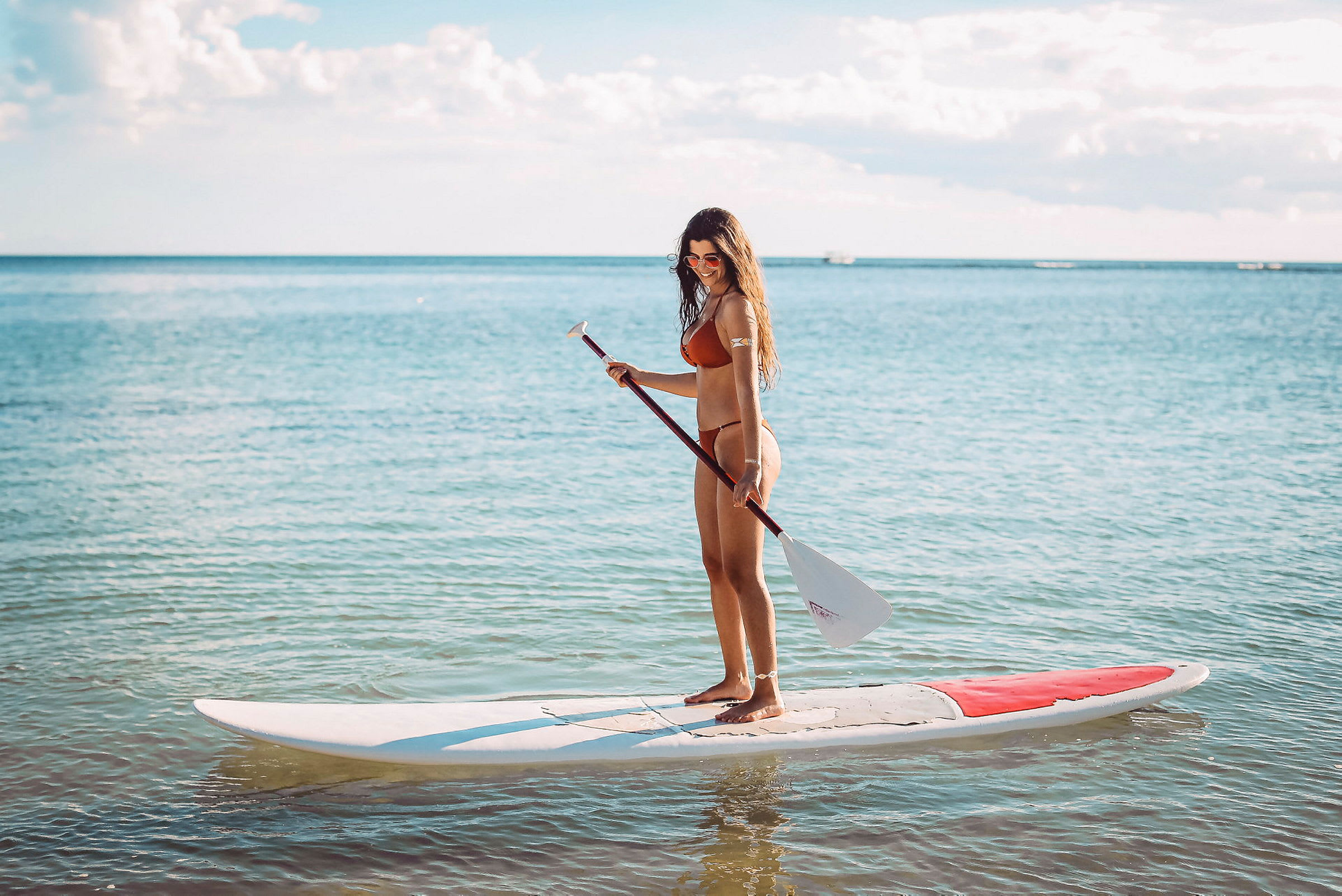 Person står på et paddleboard i vandet. (AI-genereret tekst)