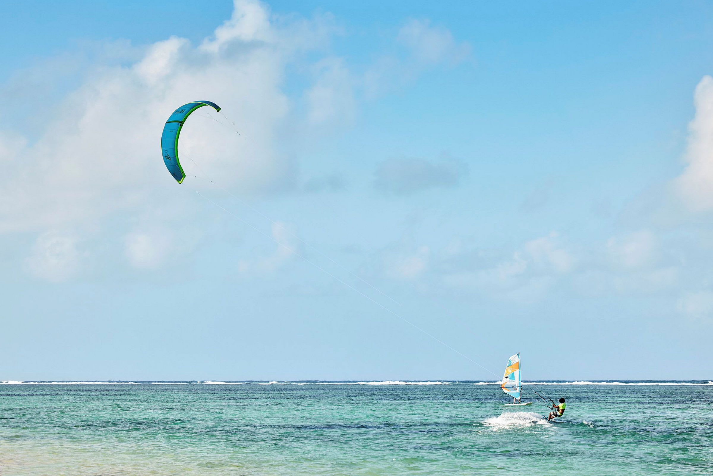 Person, der kitesurfer på havet under en blå himmel. (AI-genereret tekst)