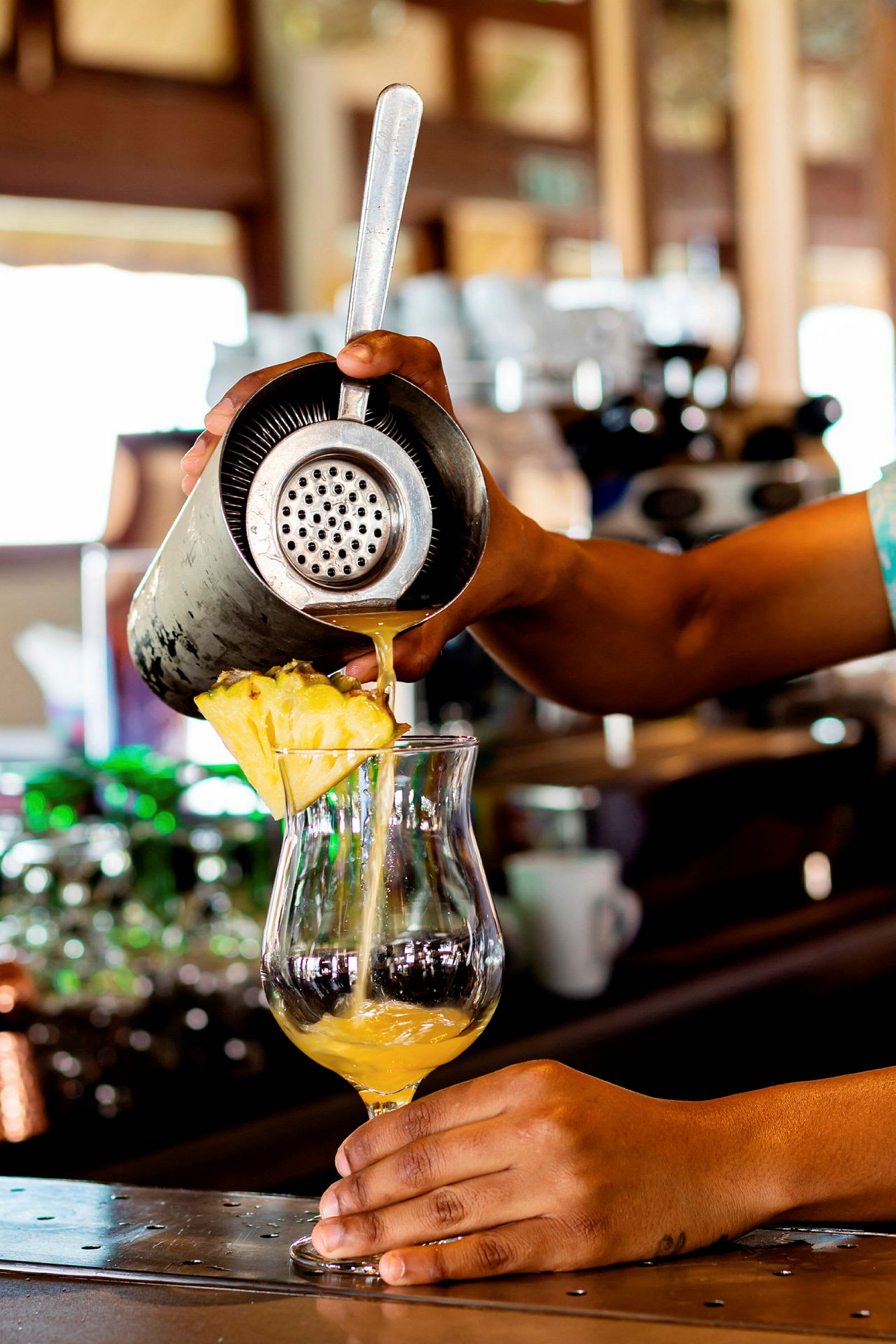 En drink bliver hældt op i et glas på en bardisk. (AI-genereret tekst)