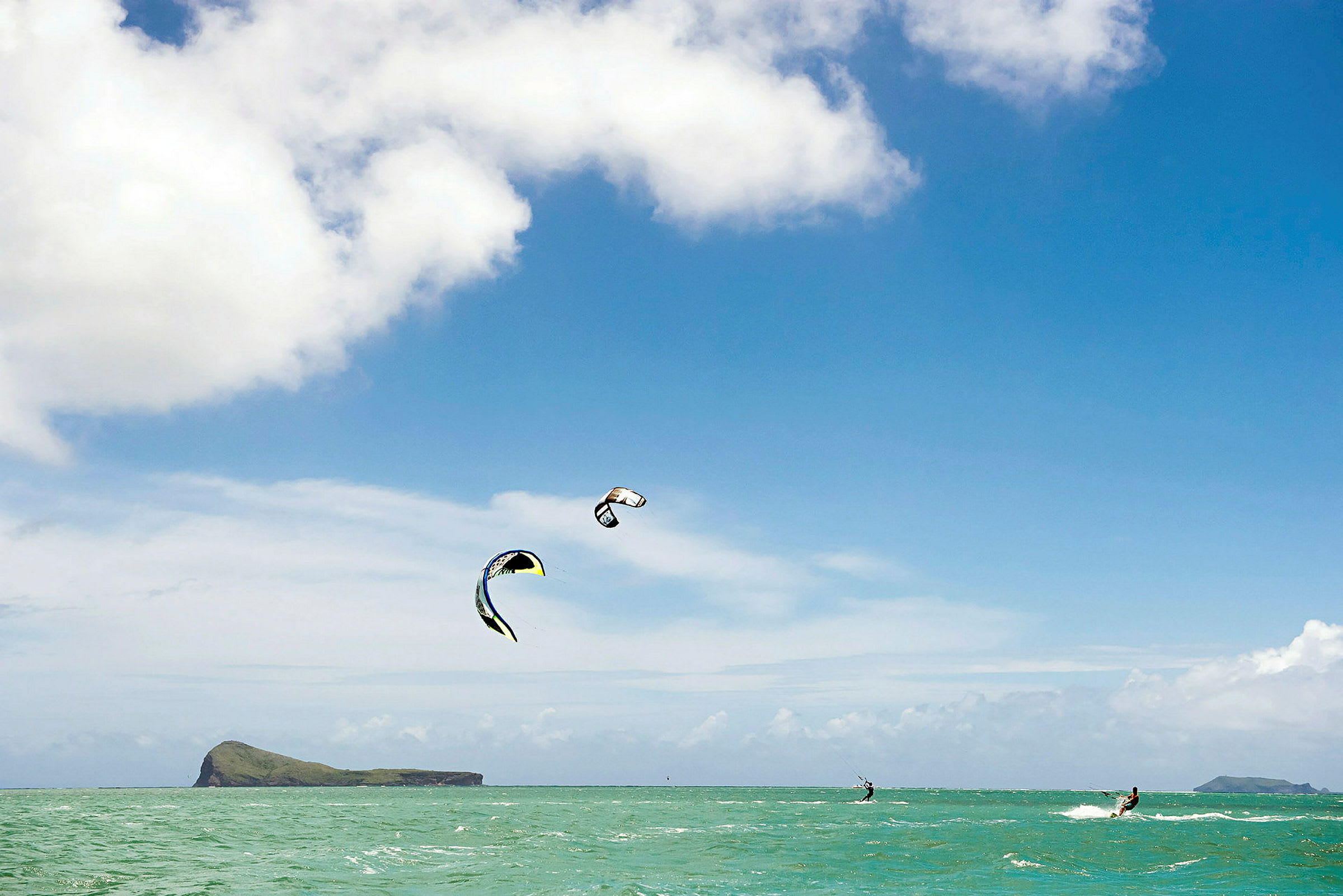 Kitesurfere på havet under klar himmel. (AI-genereret tekst)