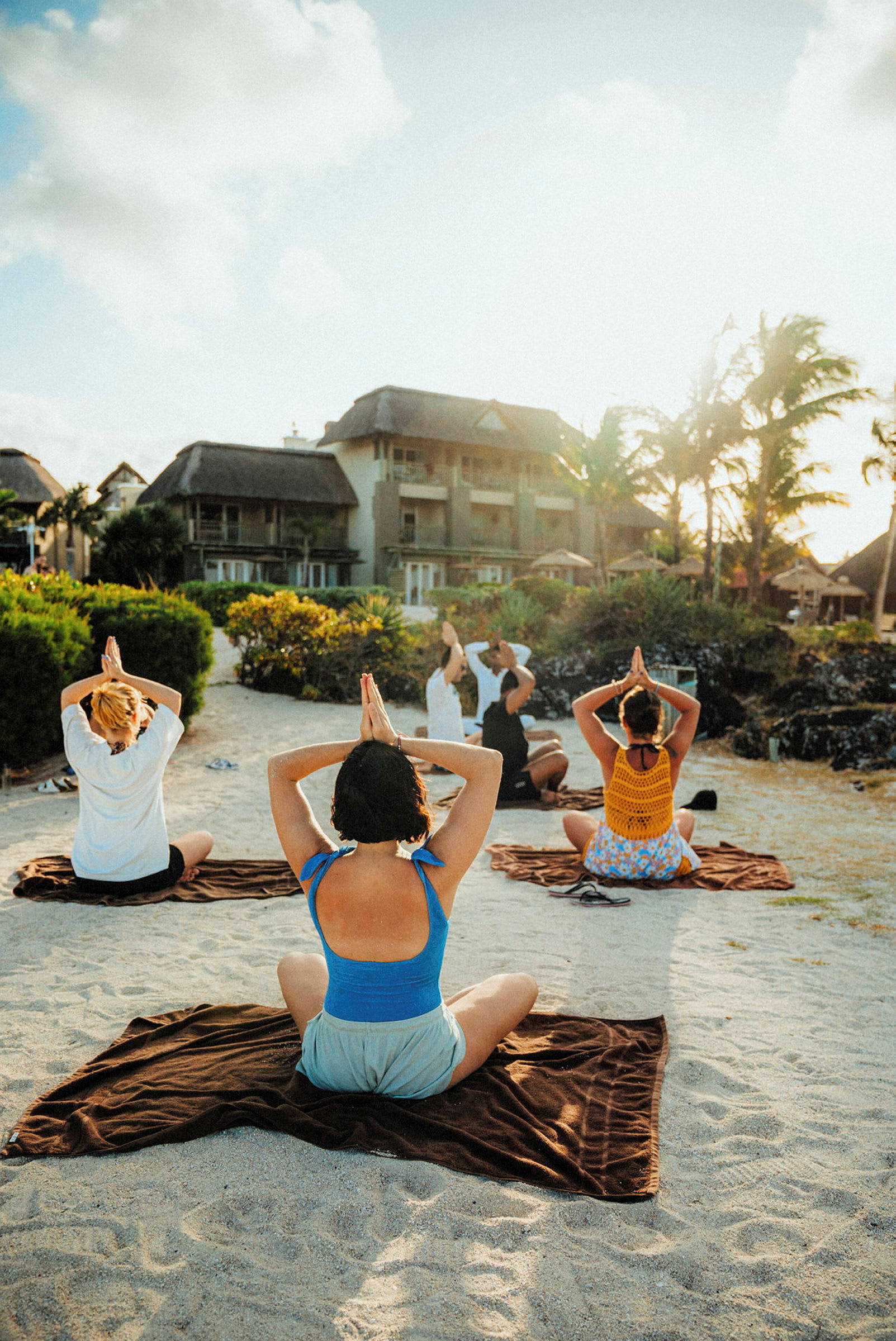 Personer laver yoga på en sandstrand. (AI-genereret tekst)