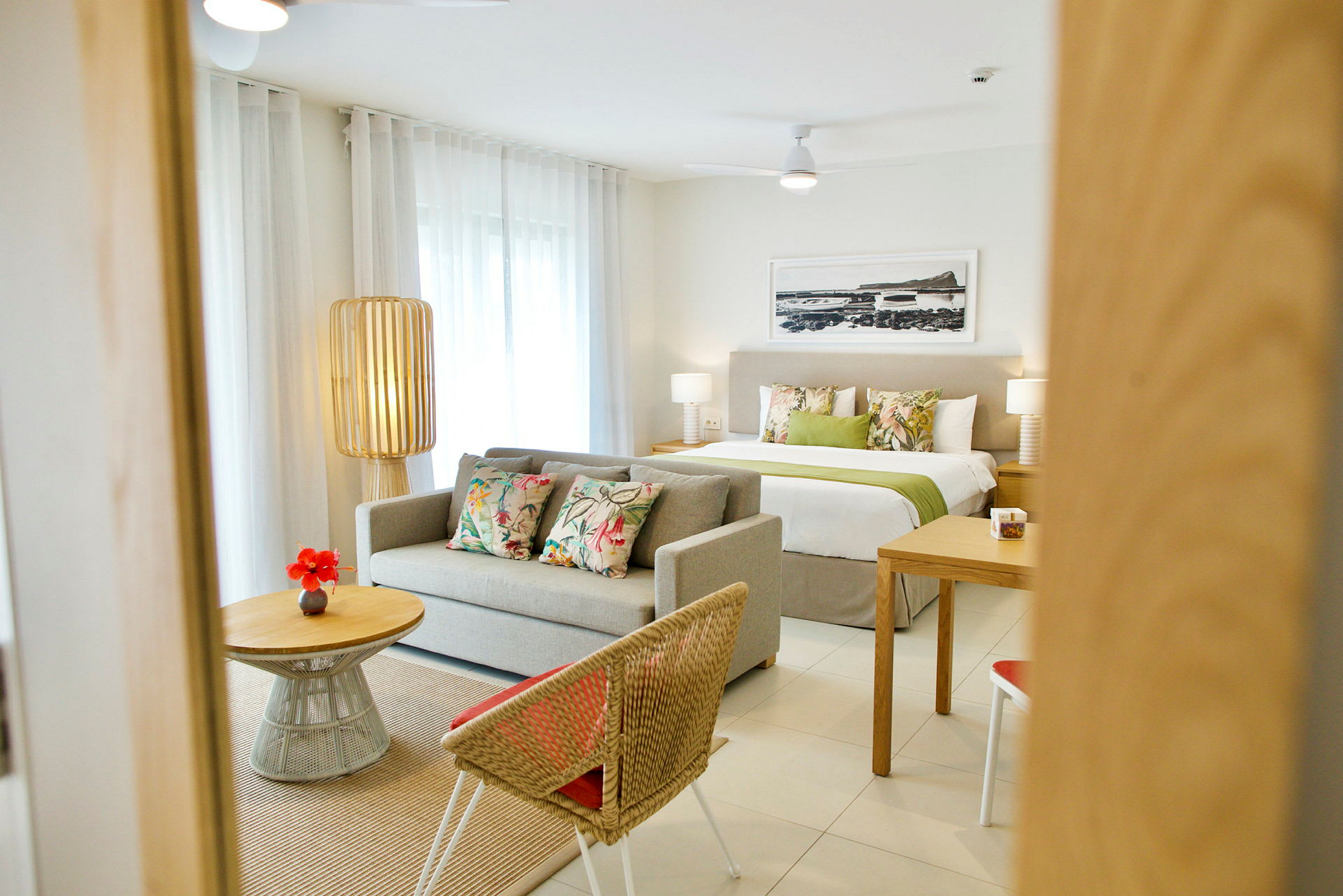 Et moderne indrettet hotelværelse med sofa, seng og bord. (AI-genereret tekst)