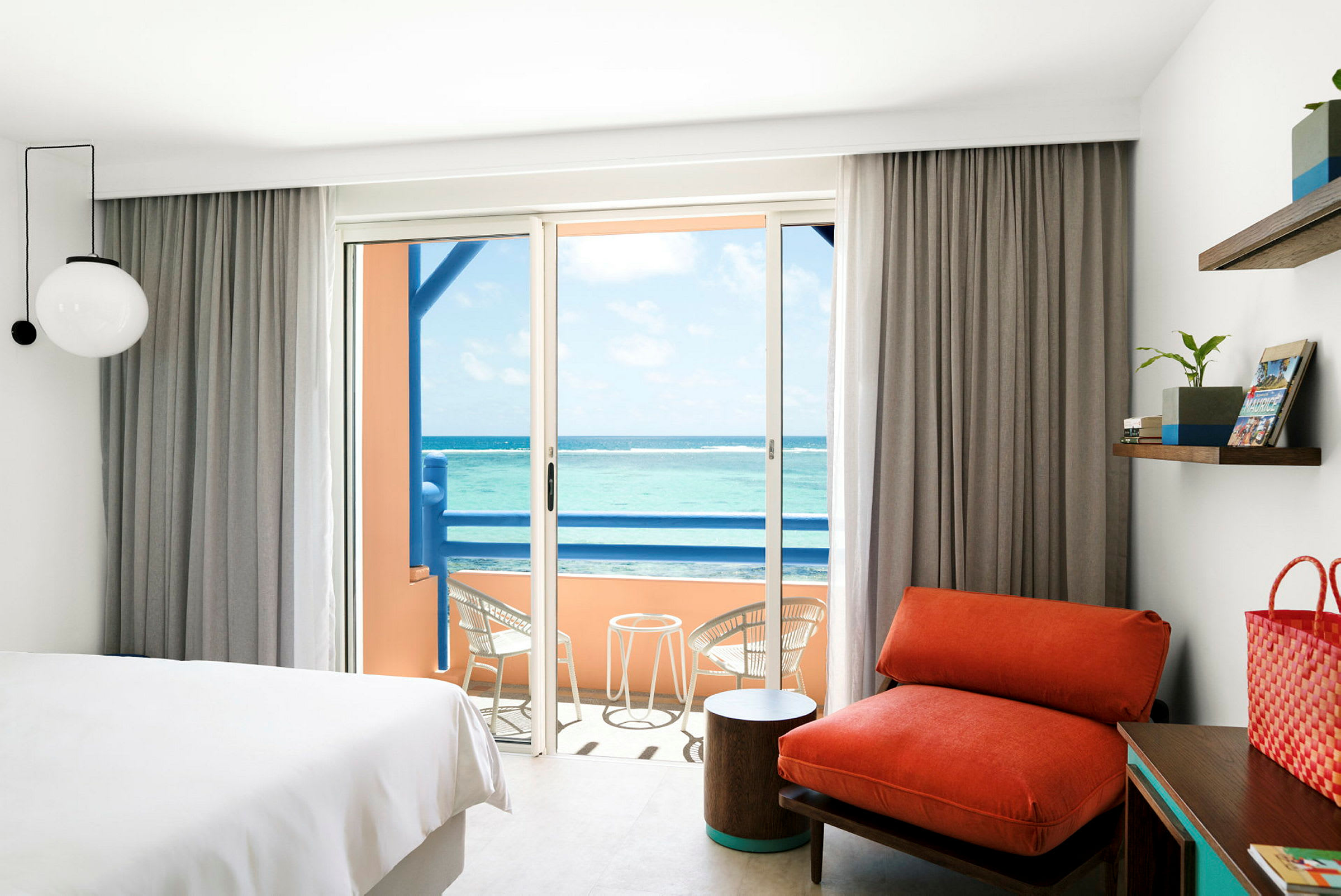 Et hotelværelse med en balkon, der har udsigt over havet. (AI-genereret tekst)