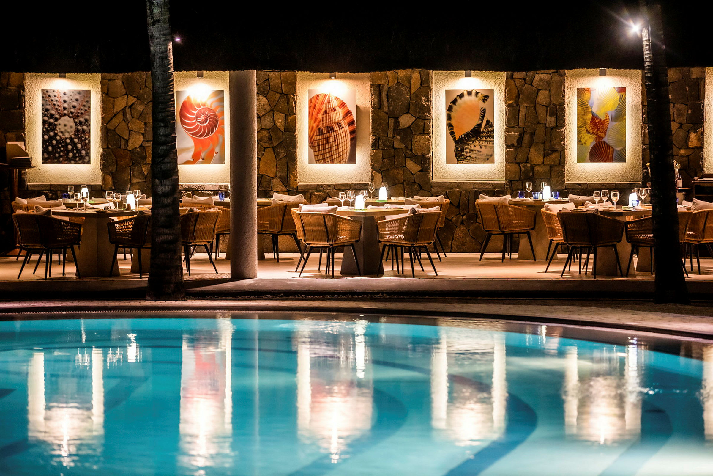 Restaurant med pool i forgrunden, belysning og vægdekorationer synlige. (AI-genereret tekst)