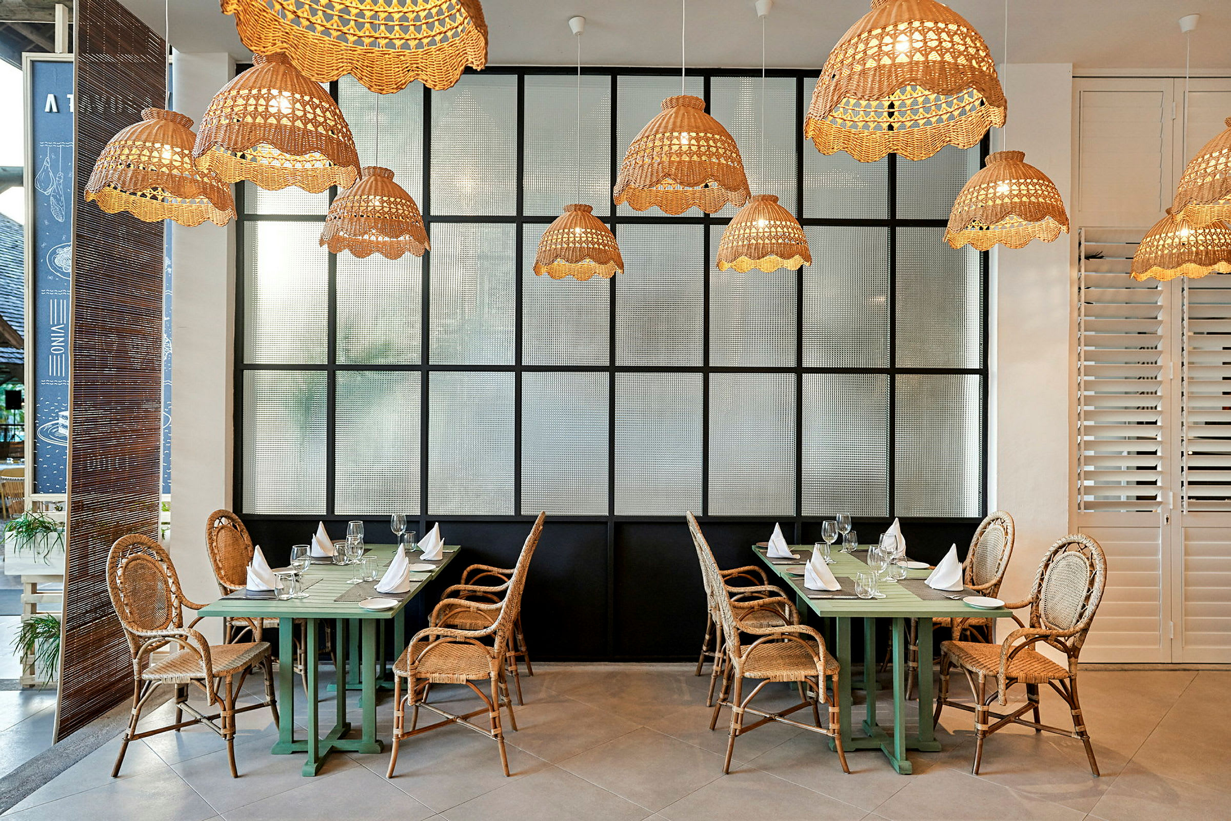 Restaurant med kurvestole og hængende lamper. (AI-genereret tekst)