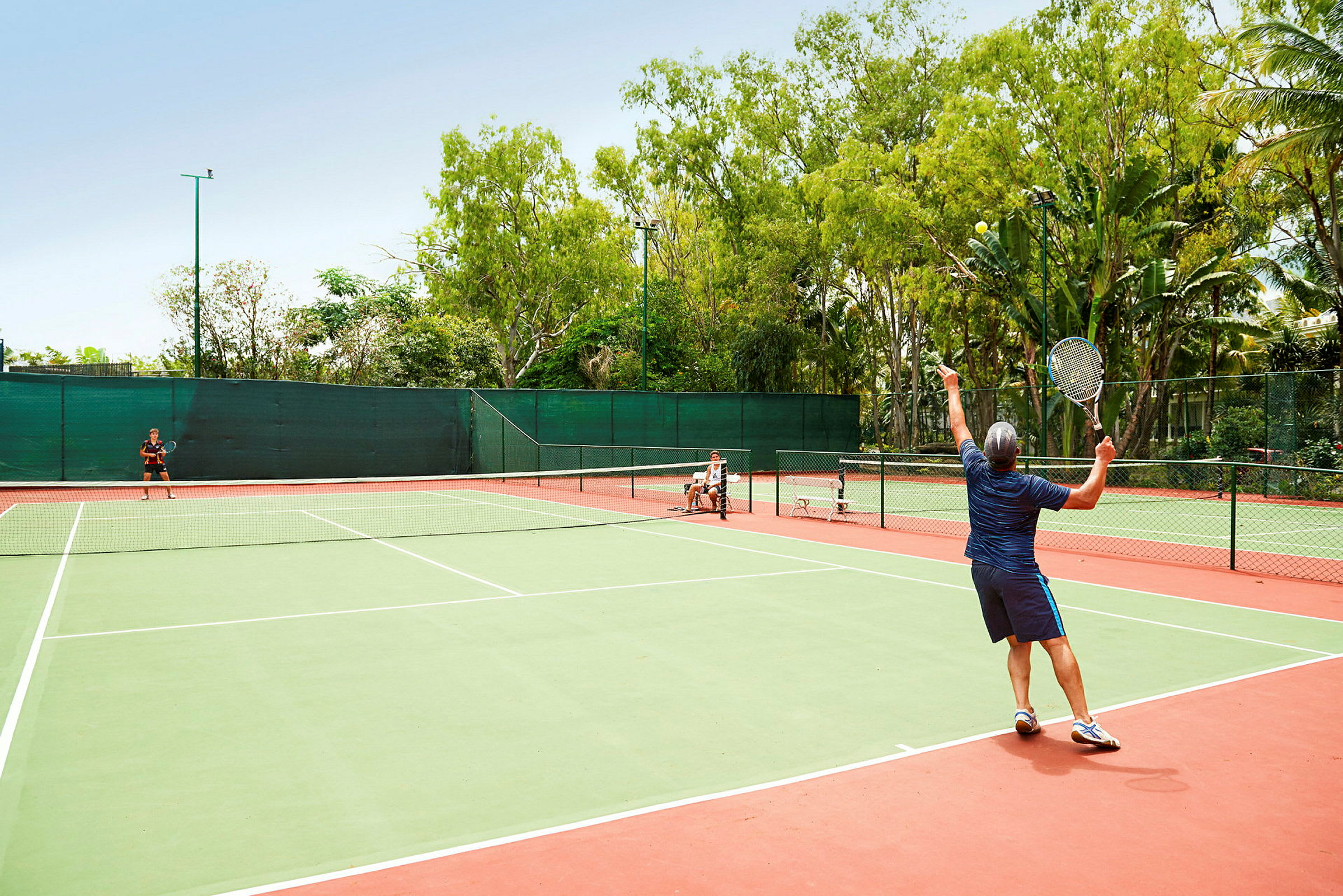 Personer spiller tennis på en udendørsbane. (AI-genereret tekst)
