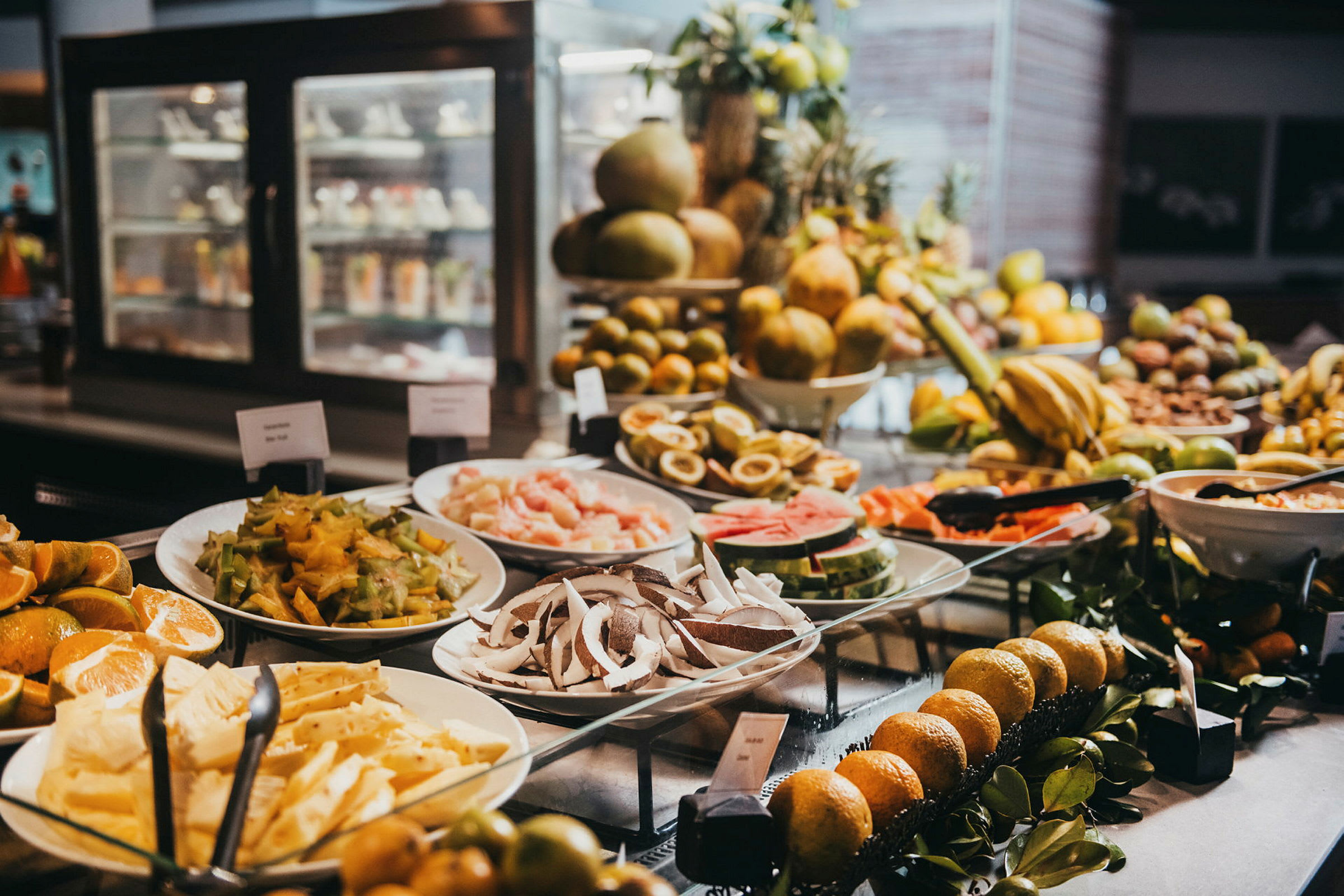 En buffet med forskellige tropiske frugter og skiver anrettet på tallerkener. (AI-genereret tekst)