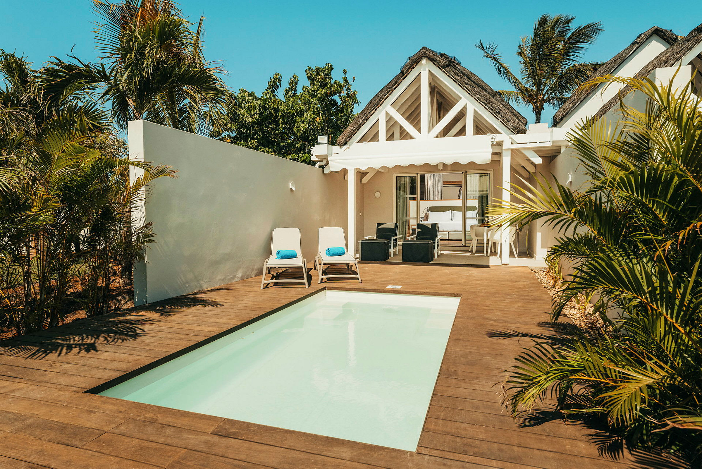 Villa med pool, liggestole og grønne omgivelser. (AI-genereret tekst)