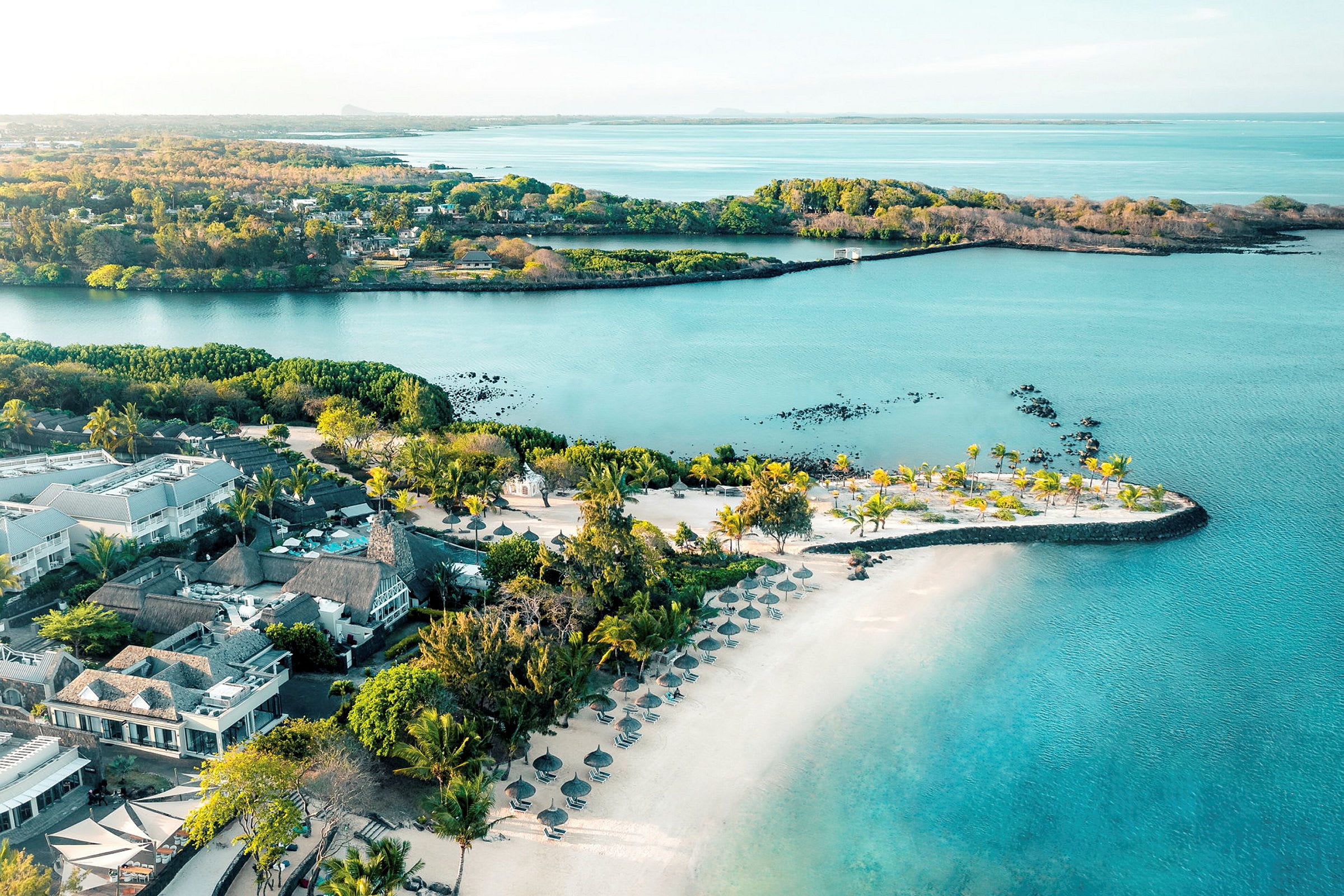 Luftfoto af resort ved vandet med palmer og strand. (AI-genereret tekst)