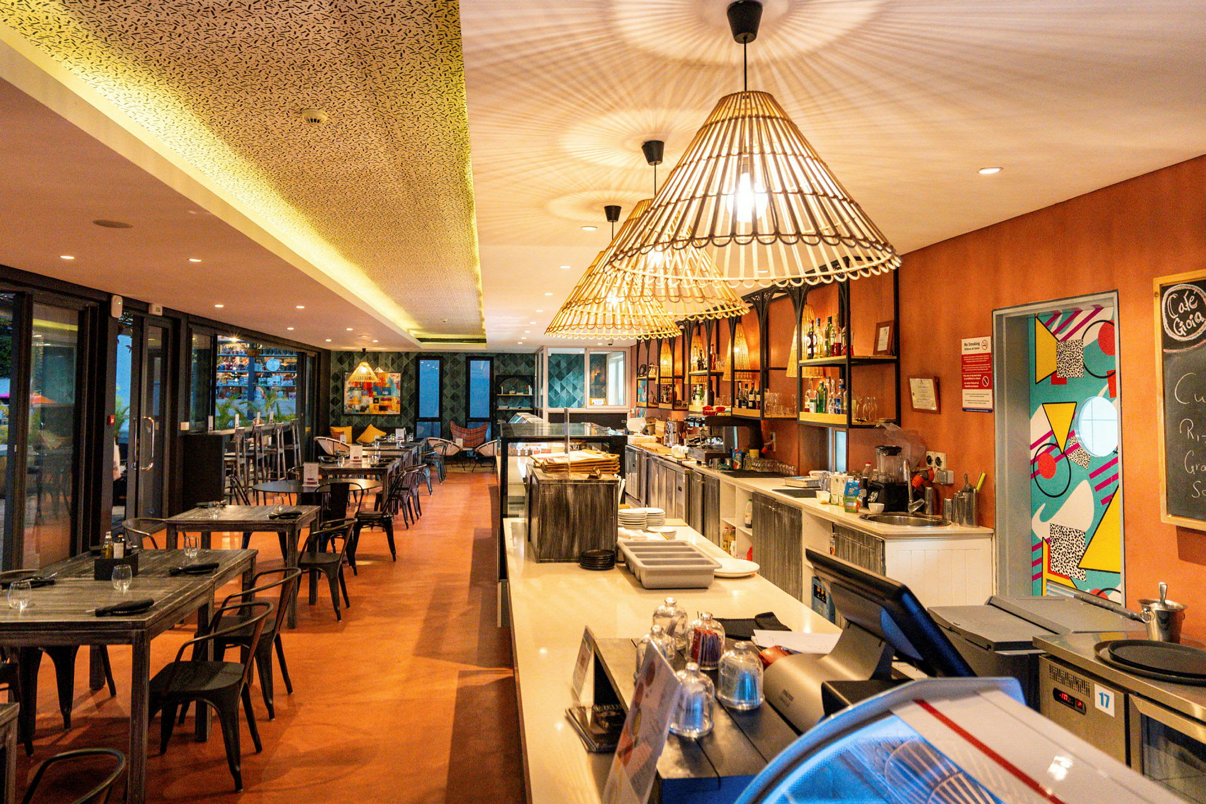 Interiør af en restaurant med borde og stole, en bar og dekorative lamper. (AI-genereret tekst)