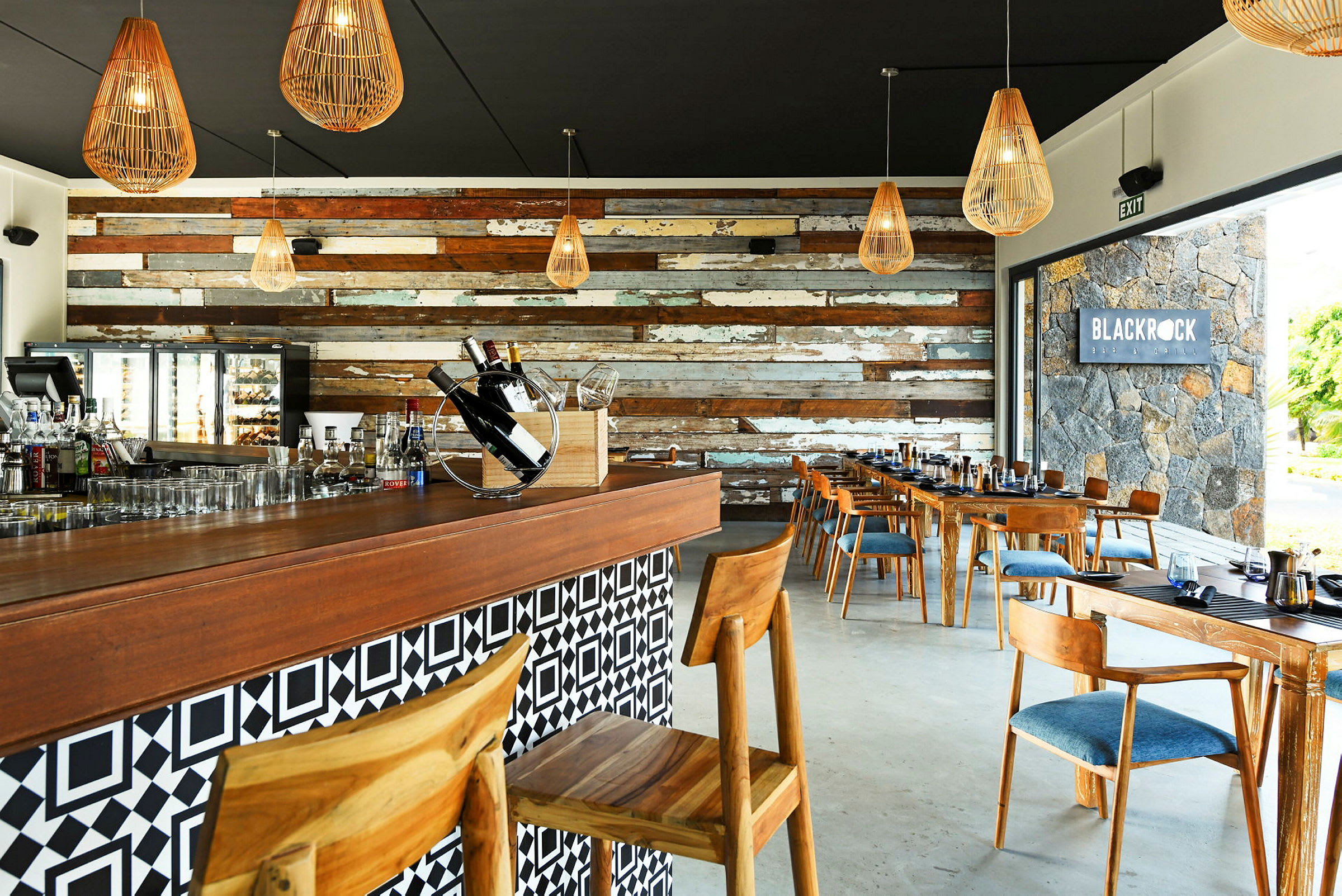 Indretning af en restaurant med trægulv og dekorative lamper. Baren har stole og borde med trædetaljer. (AI-genereret tekst)
