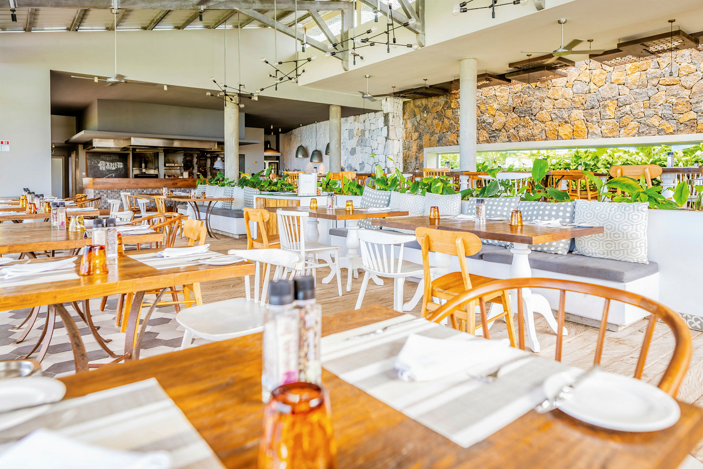 Restaurantinteriør med træborde og stole samt plantepynt. (AI-genereret tekst)
