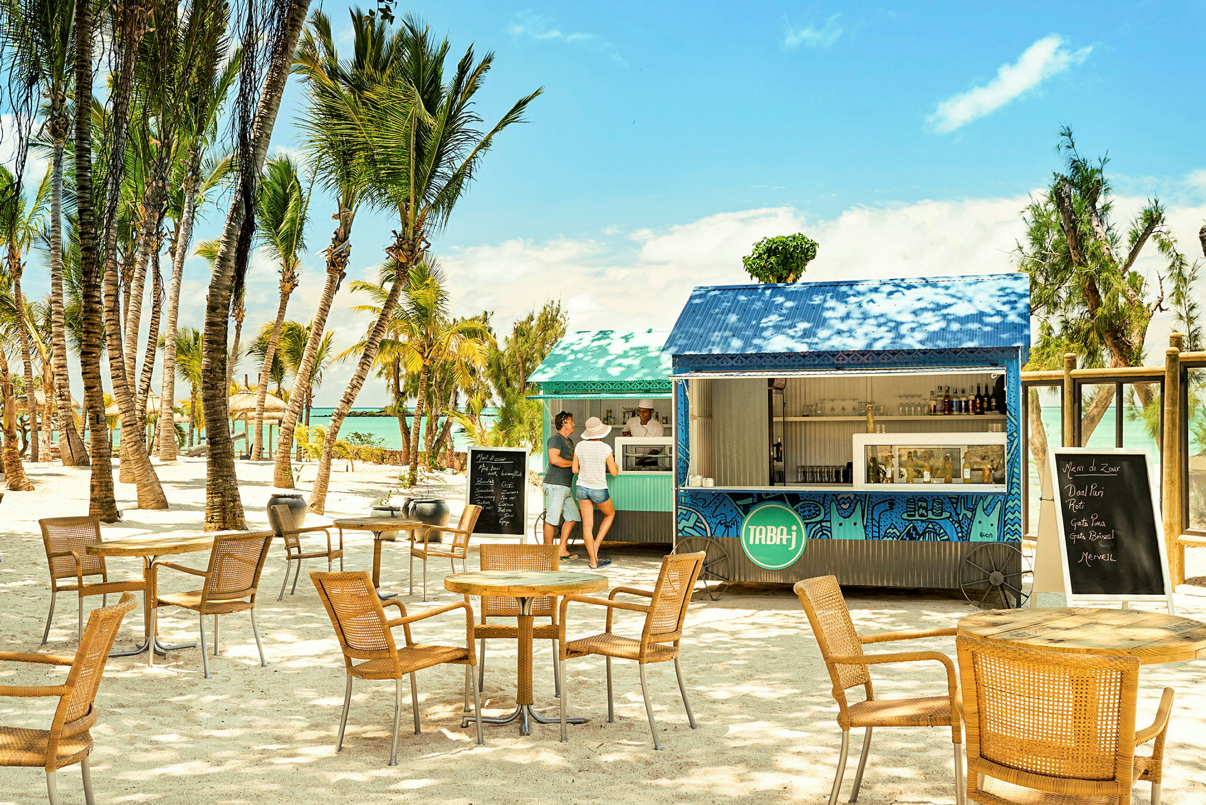 En strandbar omgivet af palmer med siddepladser og en menu på sorte tavler. (AI-genereret tekst)