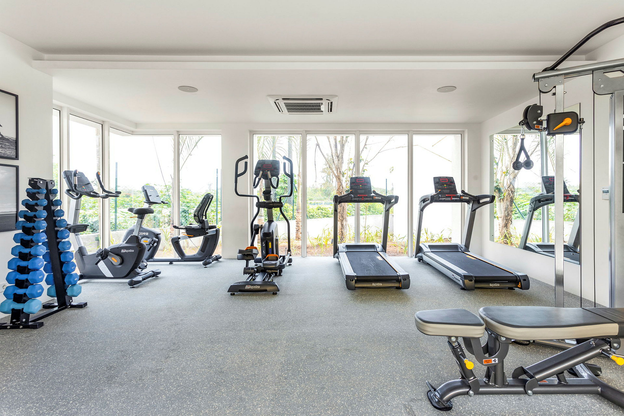 Billede af et fitnesscenter med træningsudstyr som løbebånd, motionscykler og vægte. (AI-genereret tekst)