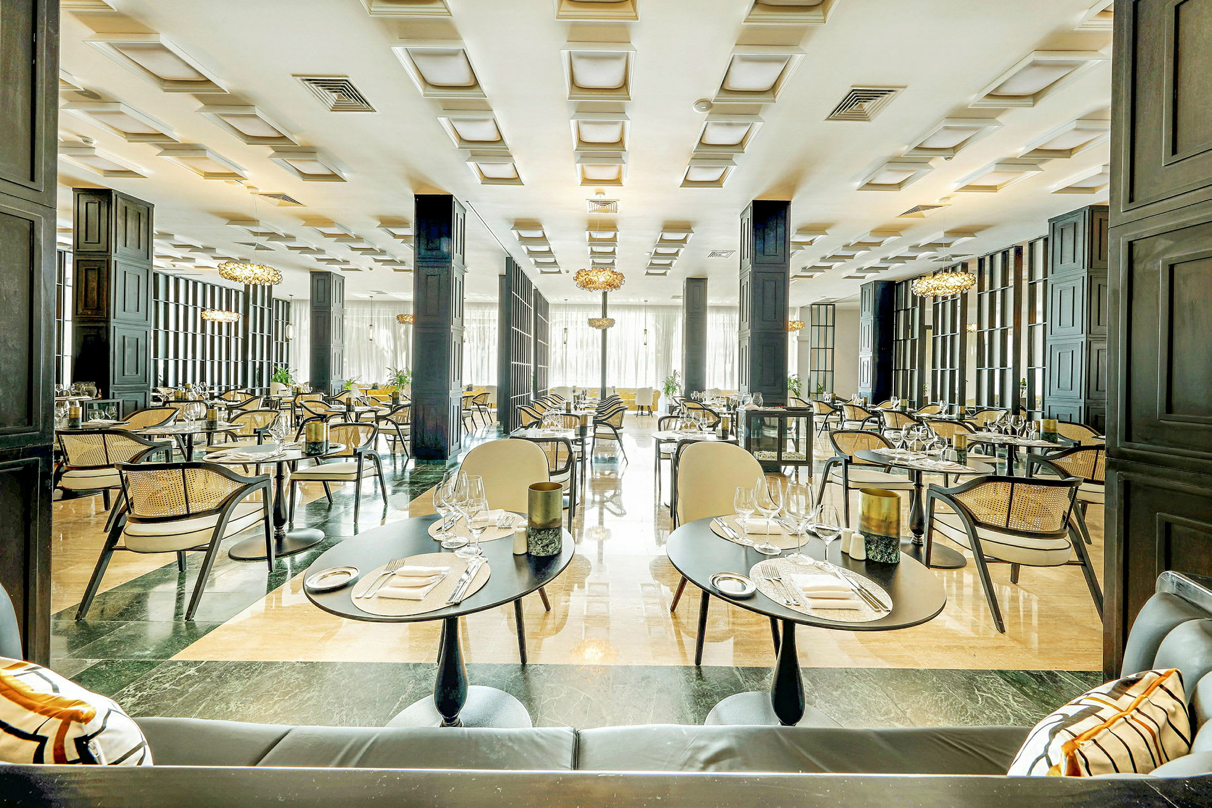 En elegant restaurant med dækkede borde, stole og moderne indretning. (AI-genereret tekst)