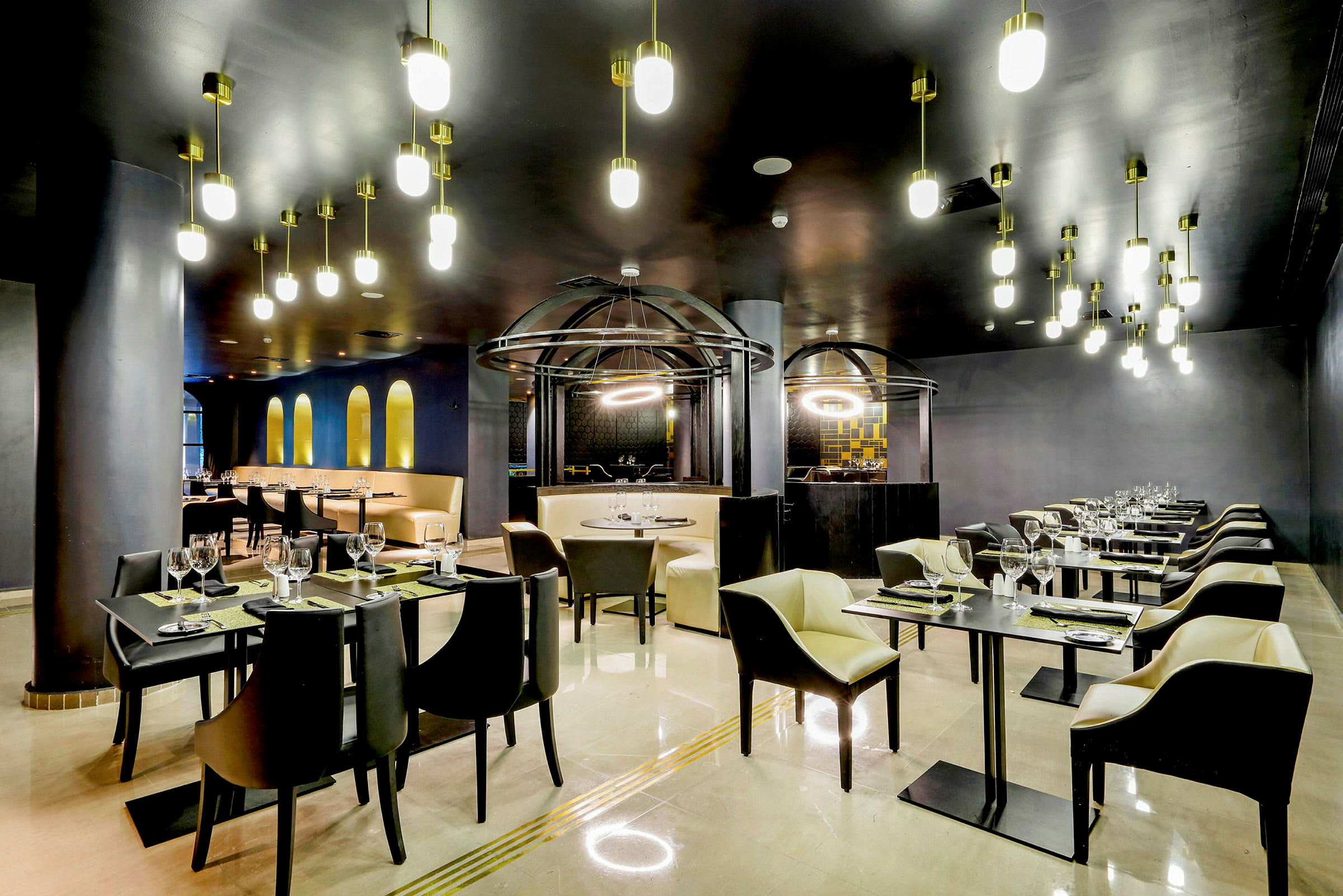 En elegant indrettet restaurant med moderne lamper, dækket borde og stole. (AI-genereret tekst)