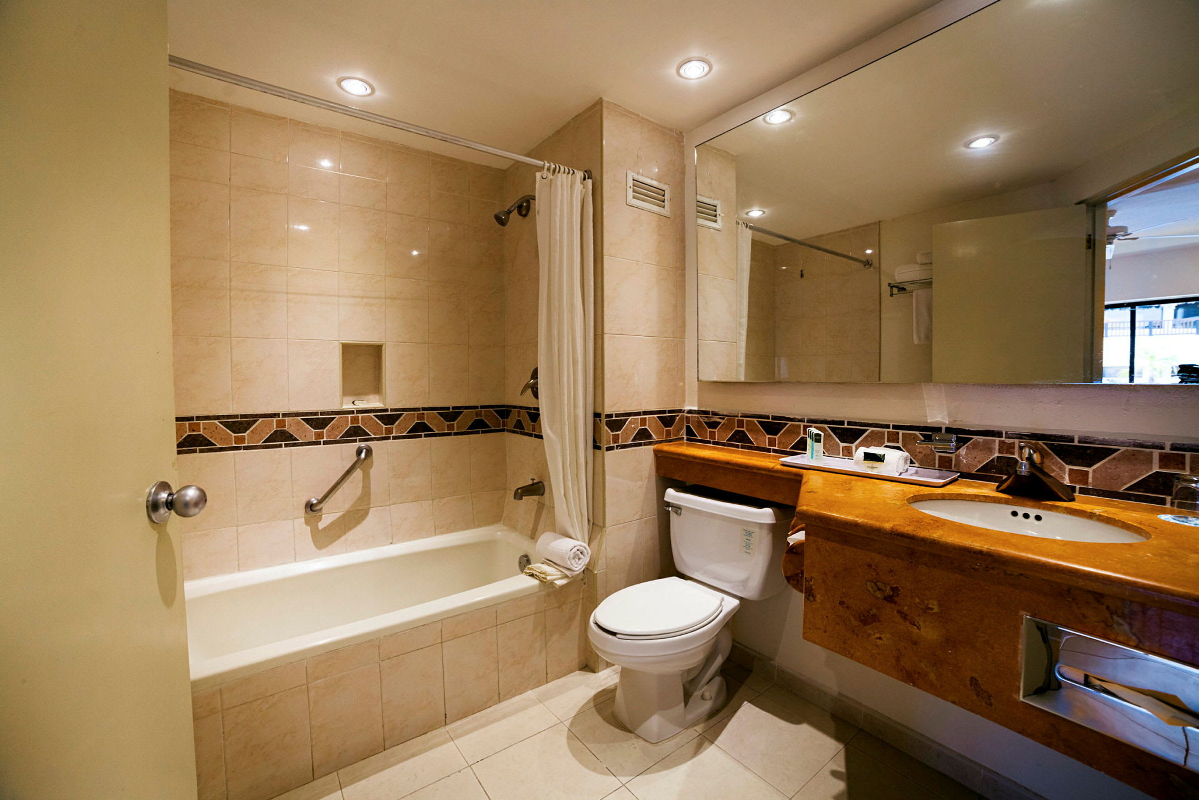 Et moderne badeværelse med badekar, toilet og håndvask med spejl over. (AI-genereret tekst)