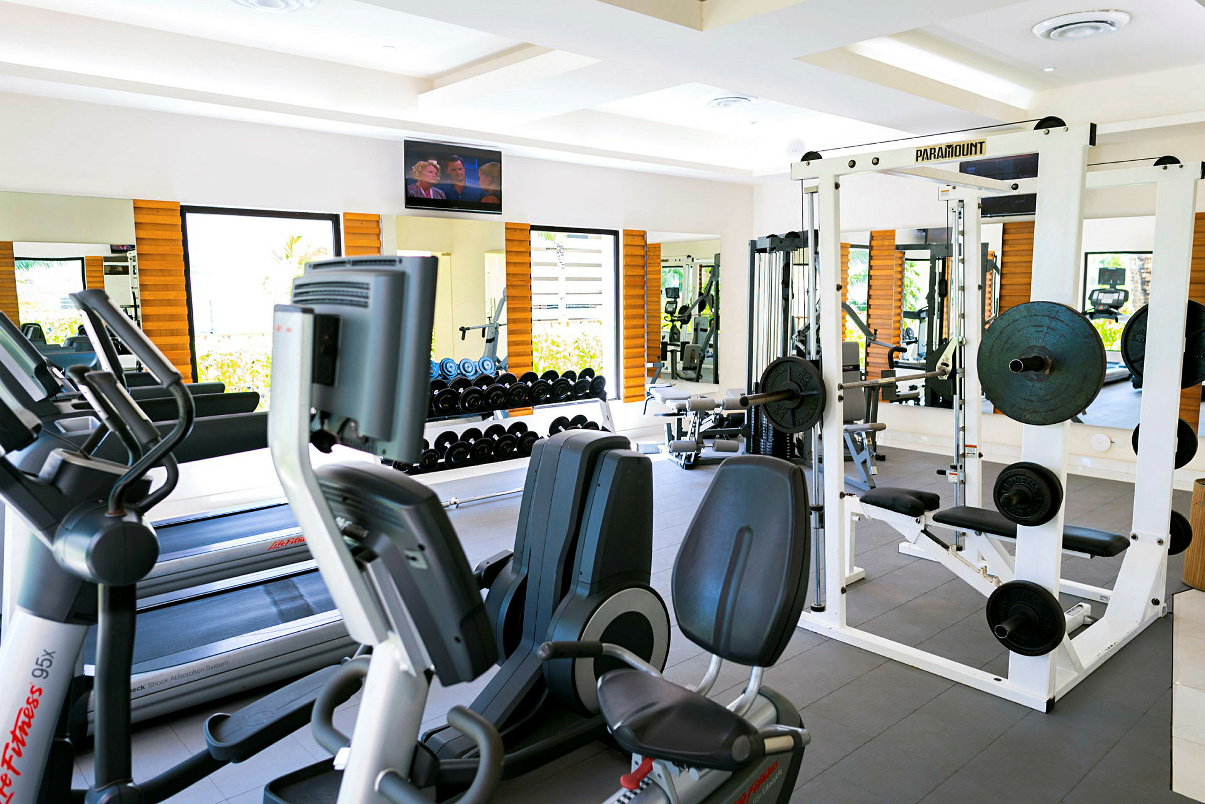 Et fitnesscenter med træningsmaskiner, frie vægte og spejle. (AI-genereret tekst)
