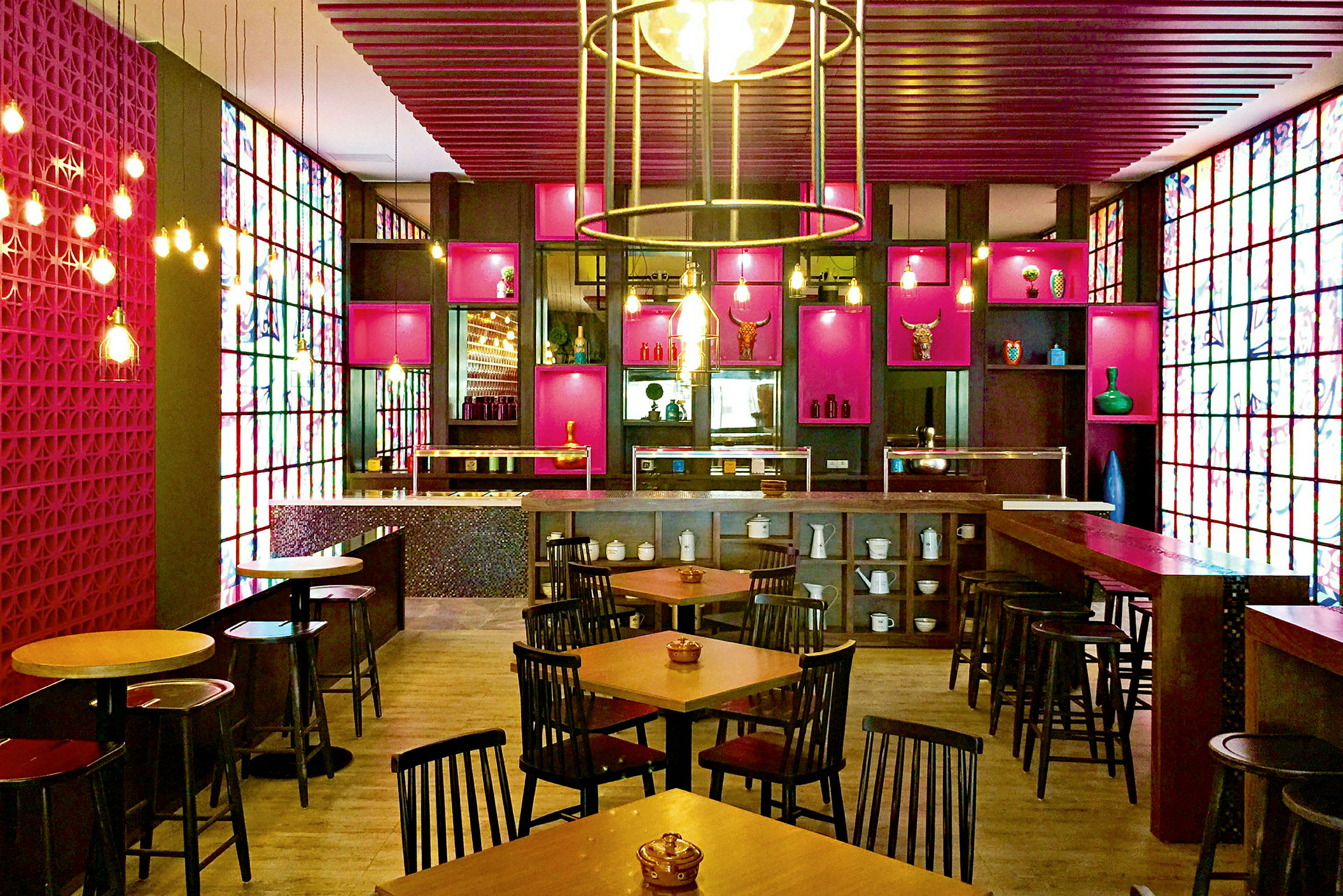 En restaurant med farverige dekorationer, borde og stole opstillede, en bar og hylder fyldt med ornamenter. (AI-genereret tekst)