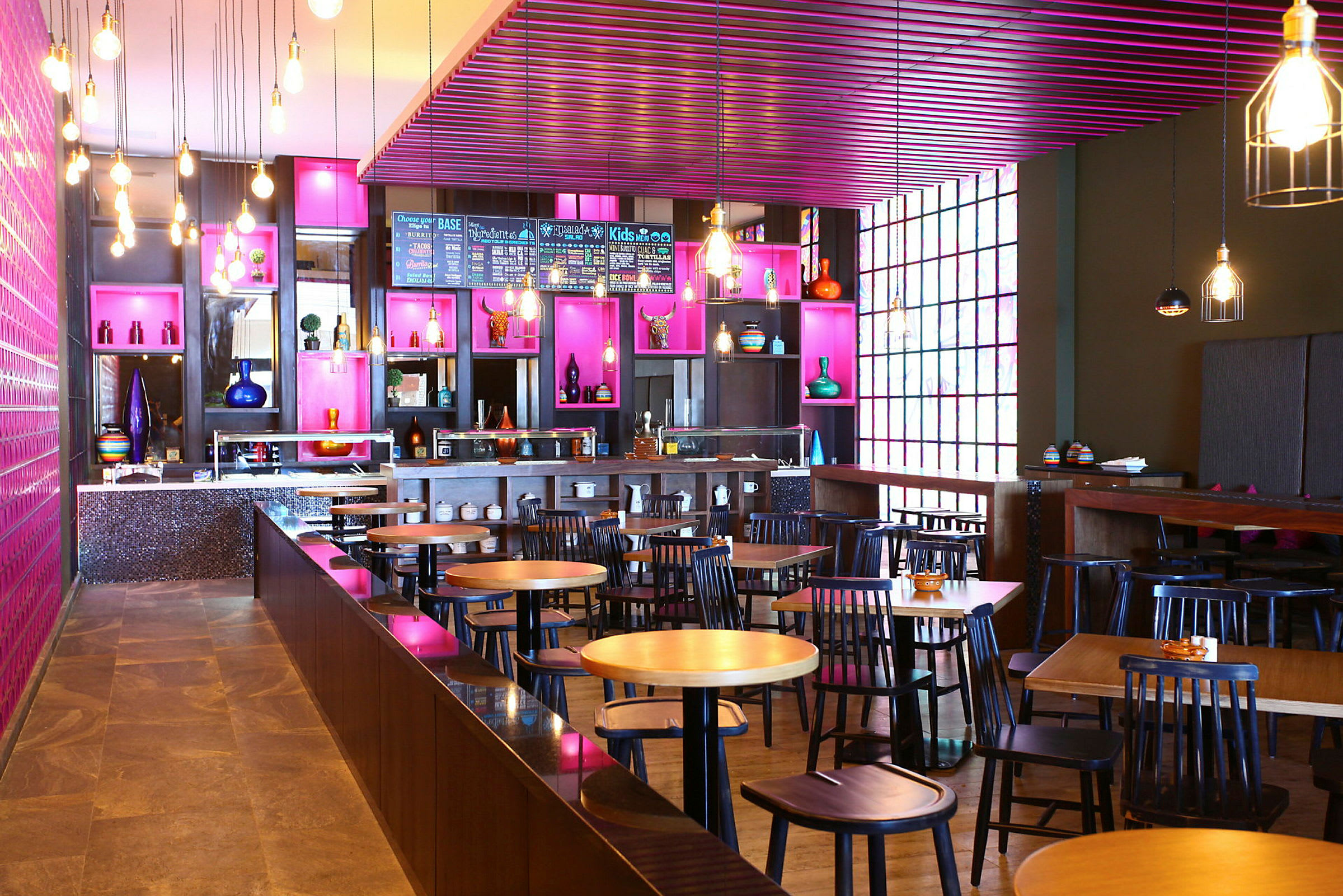 En moderne caféindretning med borde og stole, farverig dekoration og glashylder. (AI-genereret tekst)