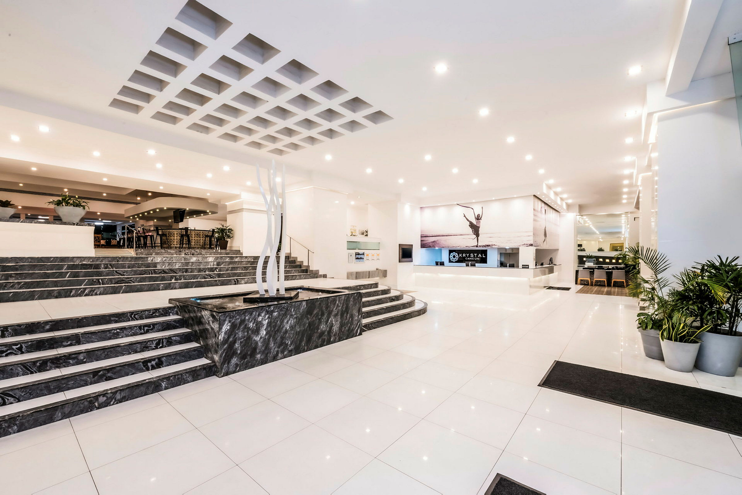 Hotellets lobby med en reception, marmorfliser og planter. (AI-genereret tekst)